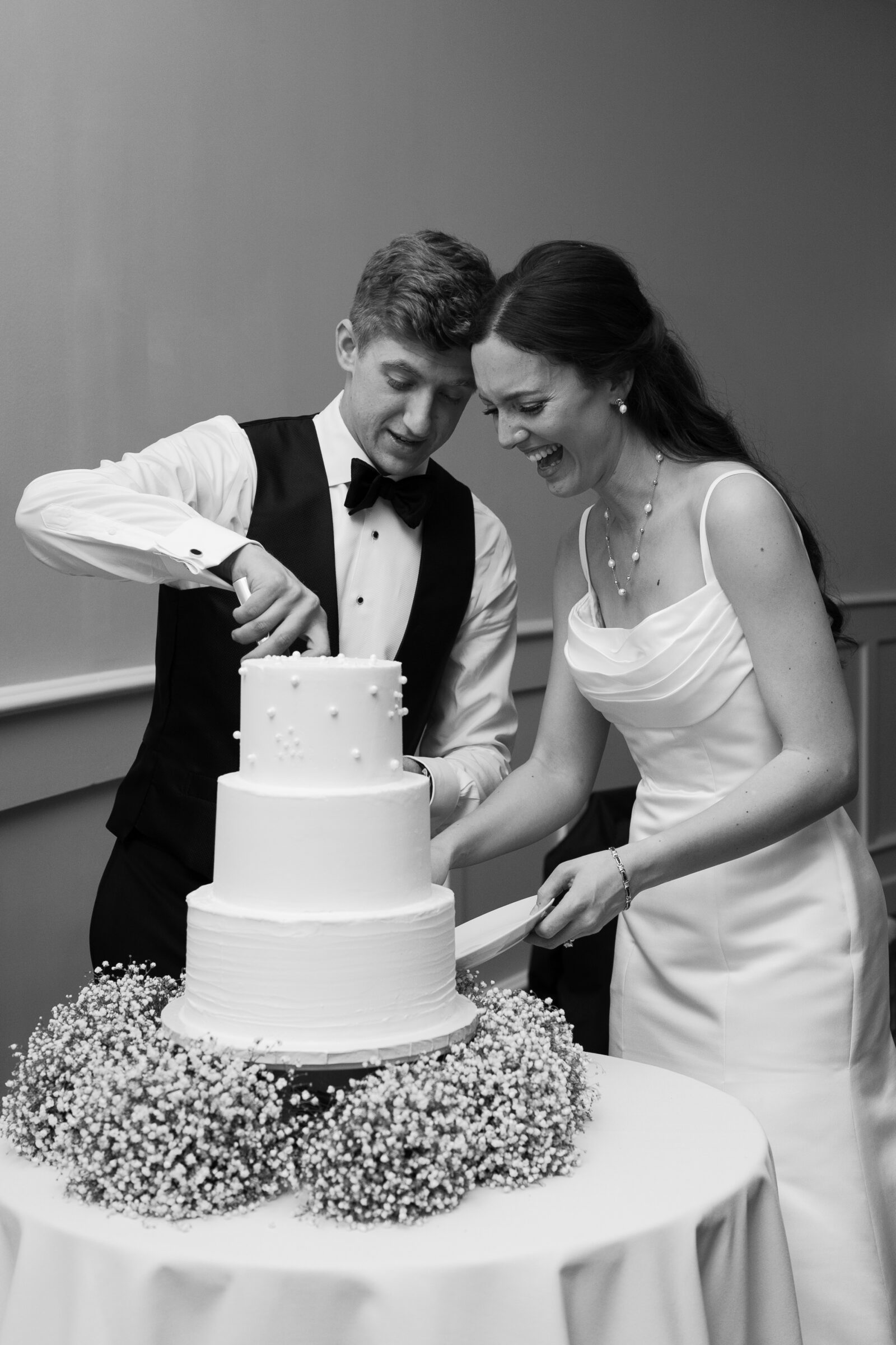 Trump Winery Grand Hall in Charlottesville, VA | black and white image of bride and groom cutting their wedding cake