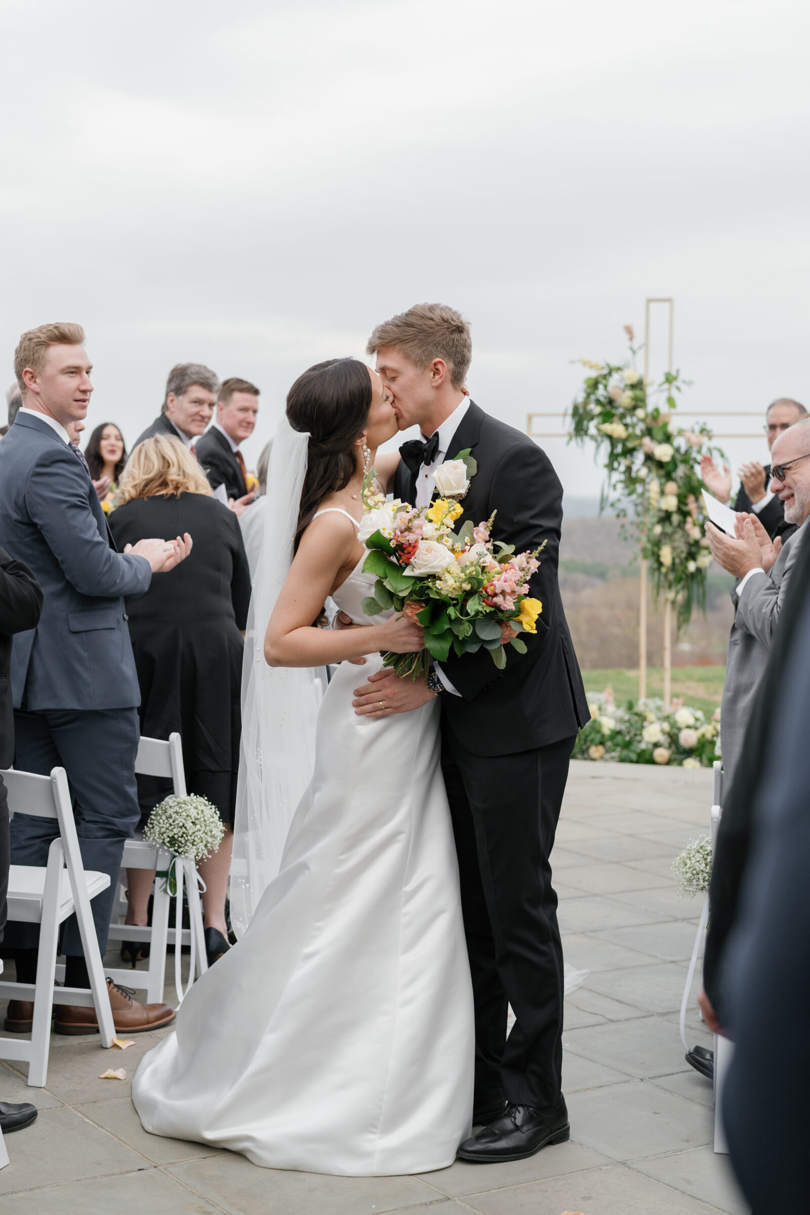 Wedding at Trump Winery Grand Hall | bride and groom share a kiss in the aisle after being married
