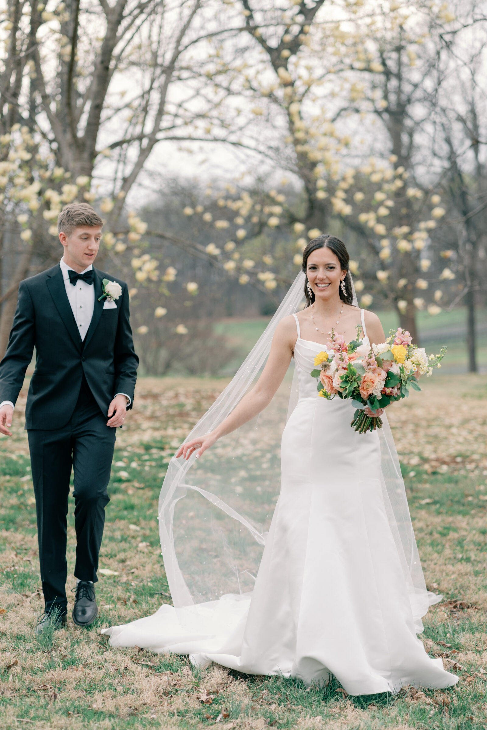 Wedding at Trump Winery in Charlottesville VA | bride plays with her veil as she walks ahead of her groom