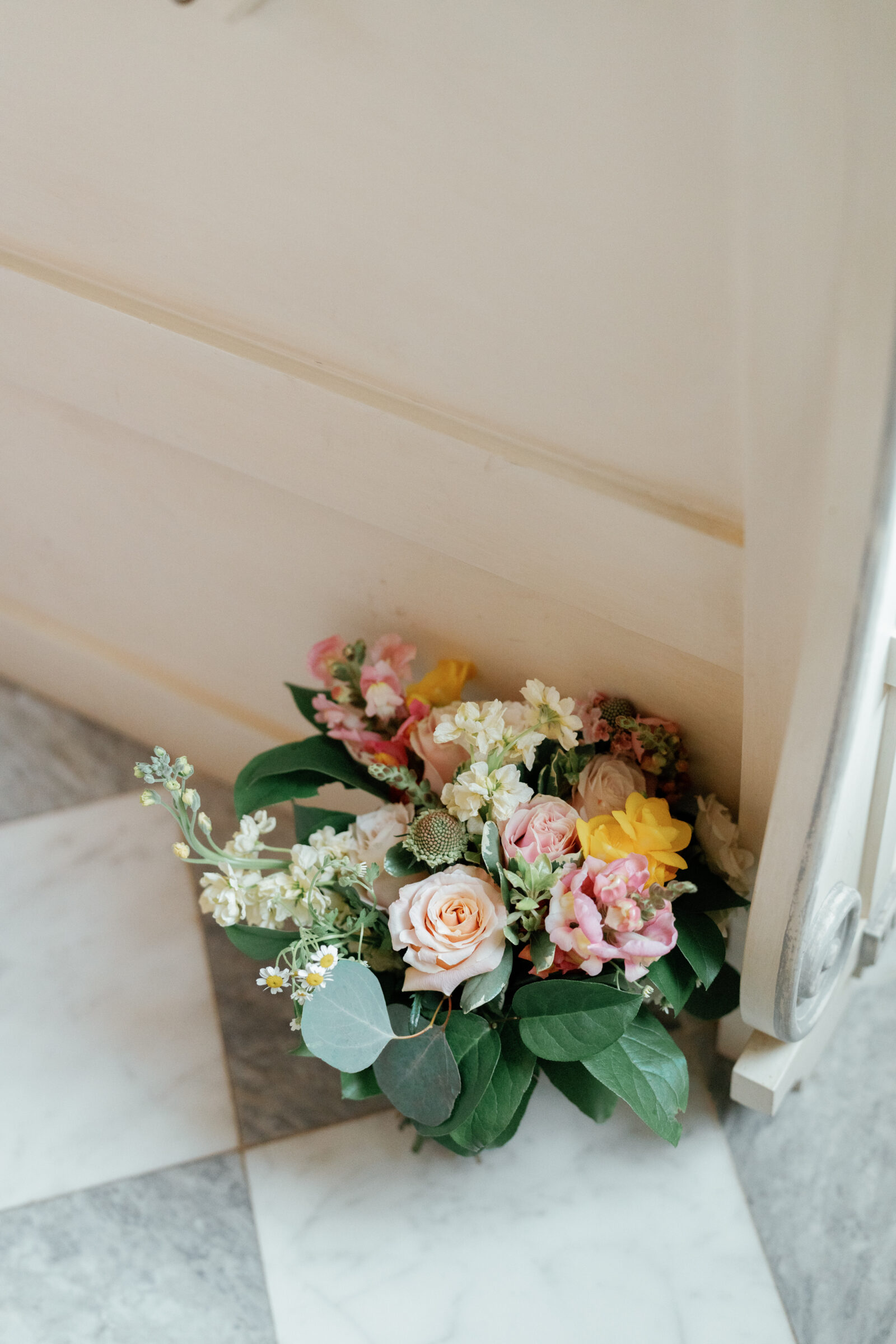 Trump Winery Chapel | bouquet resting against a pew on a checkered floor