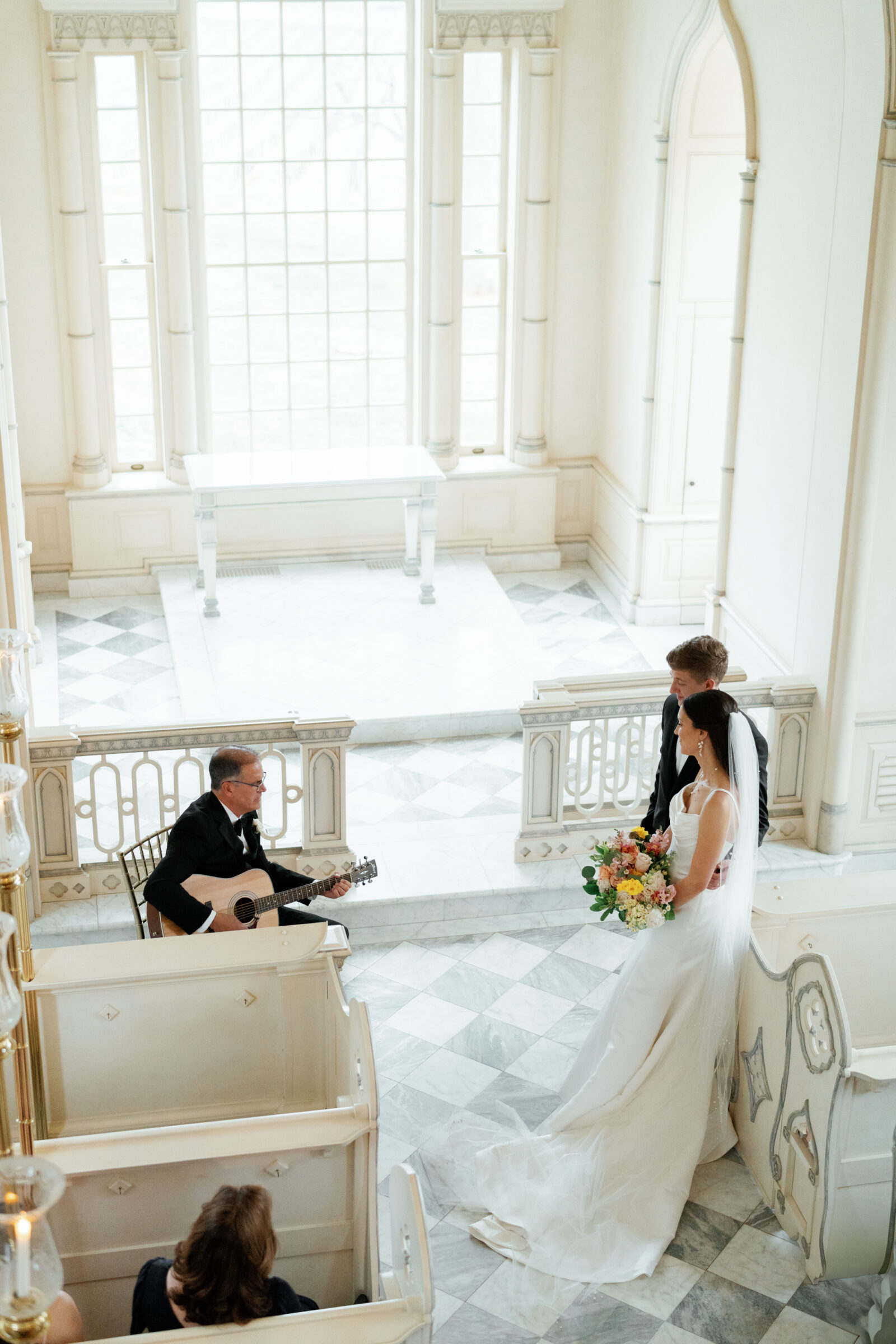 Trump Winery Chapel | bride's father plays guitar as the couple and family members watch