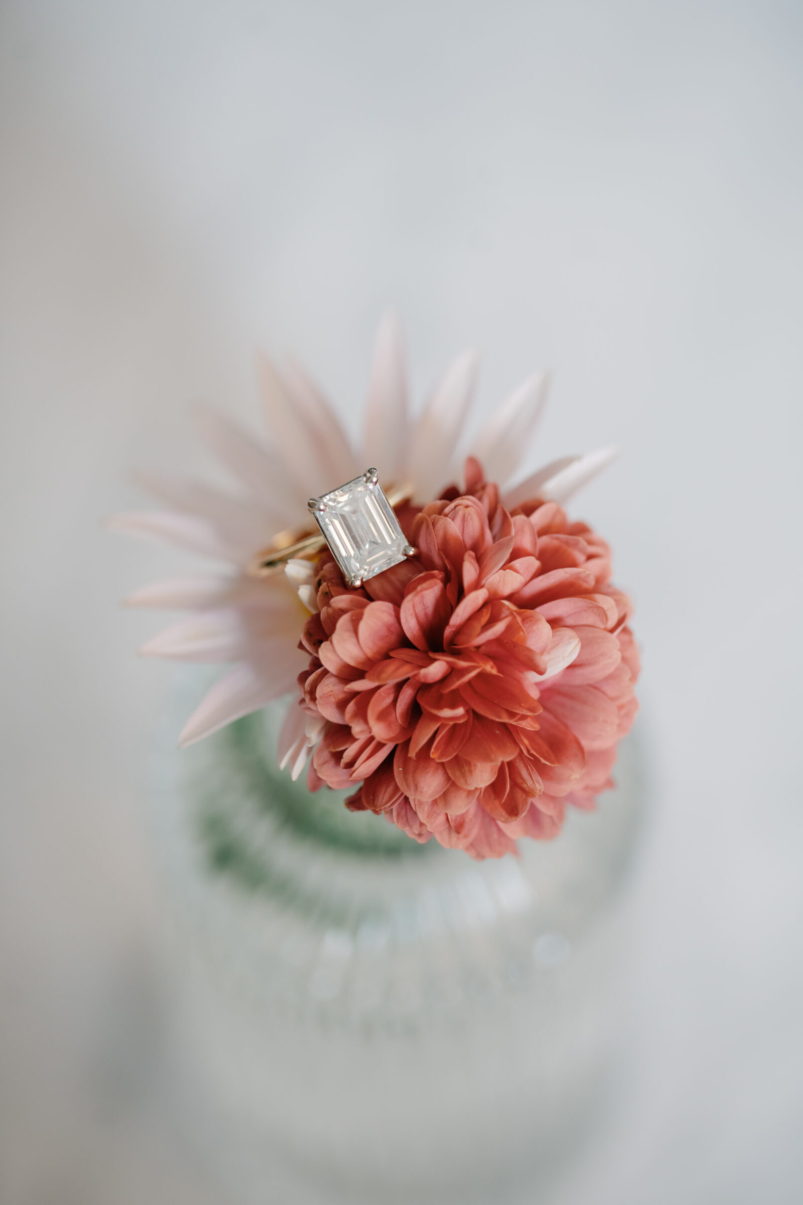 Engagement Photos Richmond VA | closeup photo of a gold, emerald-cut diamond engagement ring atop a pink flower in the Quirk Hotel lobby