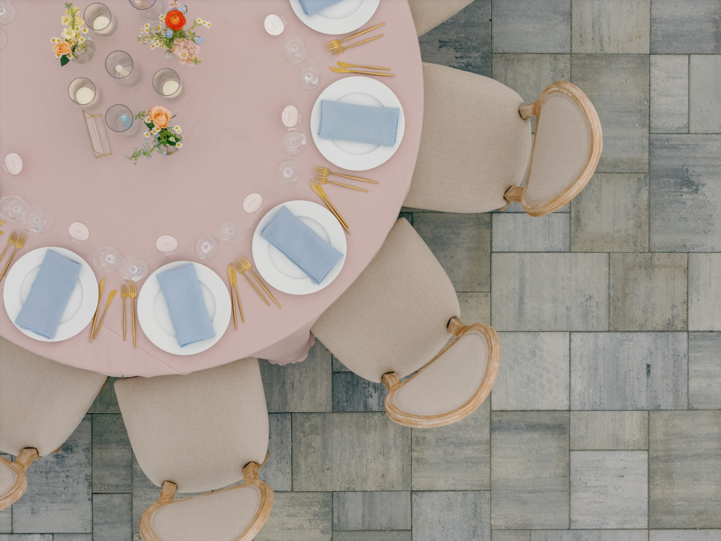 Overhead view of a round reception table at Northfield Estate in Cumberland, VA, styled with blush linens, soft blue napkins, gold flatware, and dainty floral arrangements—an elegant wedding tablescape near Richmond, Virginia.