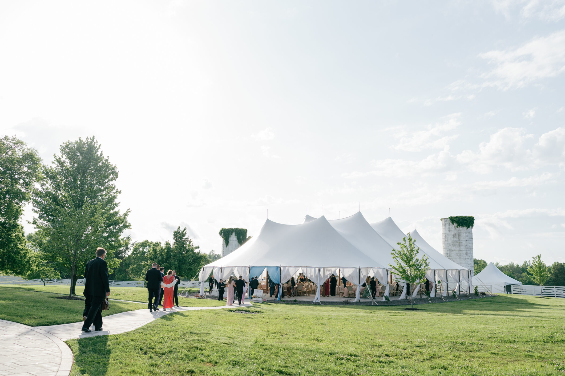 Wedding guests arriving at the sailcloth tented reception at Northfield Estate in Cumberland, VA, with white draping and countryside views—an elegant outdoor wedding venue near Richmond perfect for timeless celebrations.