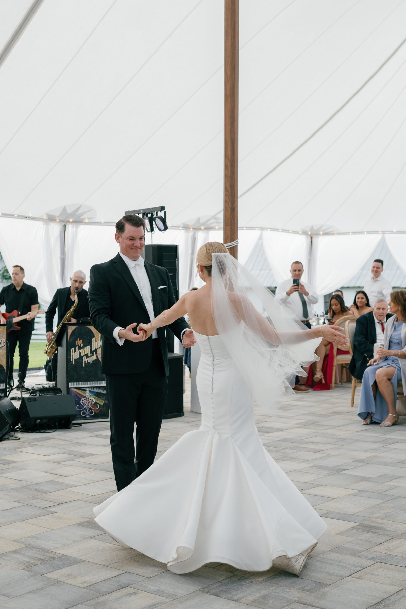 Bride and groom sharing their first dance under the sailcloth tent at Northfield Estate in Cumberland, VA, surrounded by loved ones and live band music—capturing the energy and elegance of a classic Virginia wedding near Richmond.
