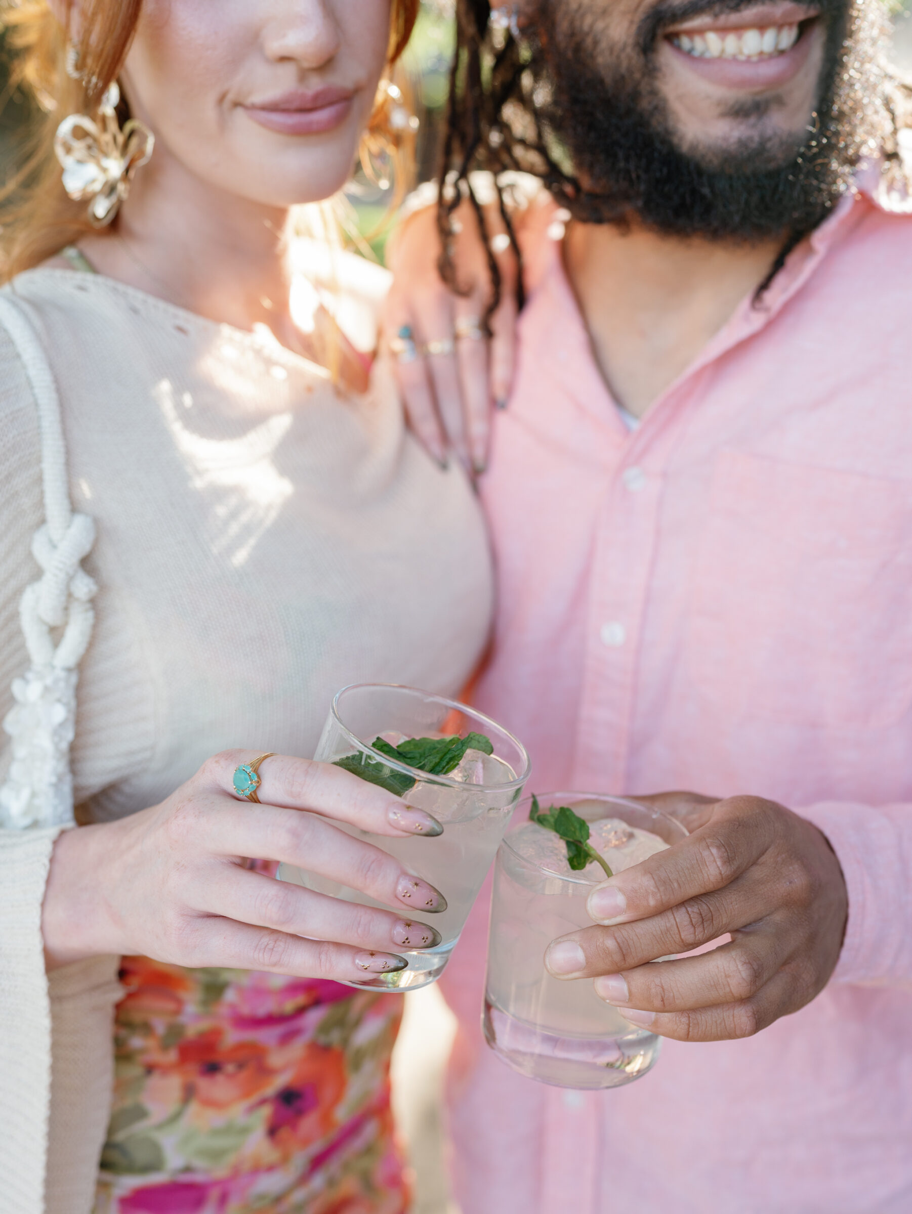 Close‑up of two guests toasting with mint‑garnished cocktails in crystal glasses at a Trump Winery Wedding in Charlottesville