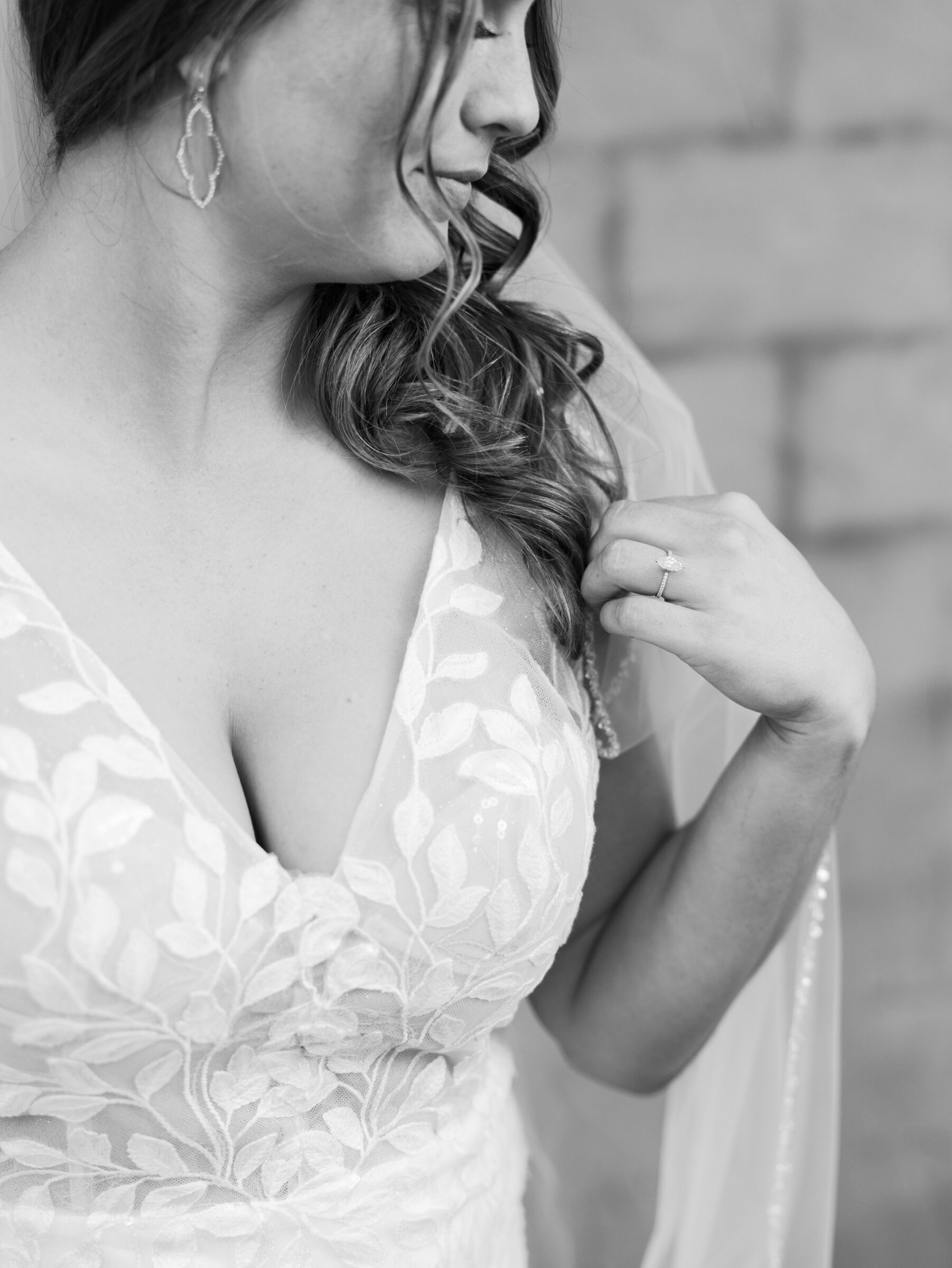 Black and white bridal portrait highlighting the bride’s lace wedding gown and engagement ring before the ceremony at Ashton Creek Vineyards.