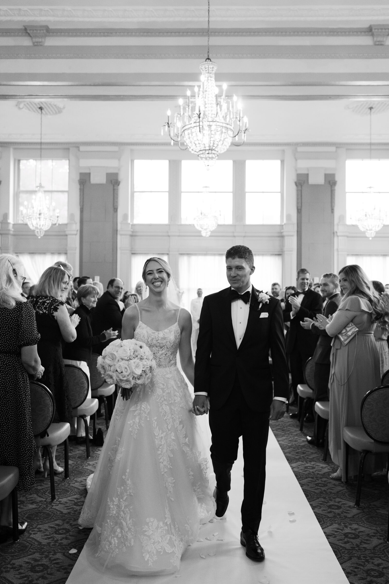Bride and groom walking down the aisle after their wedding ceremony in the Virginia Ballroom at the Hotel John Marshall in Richmond VA.