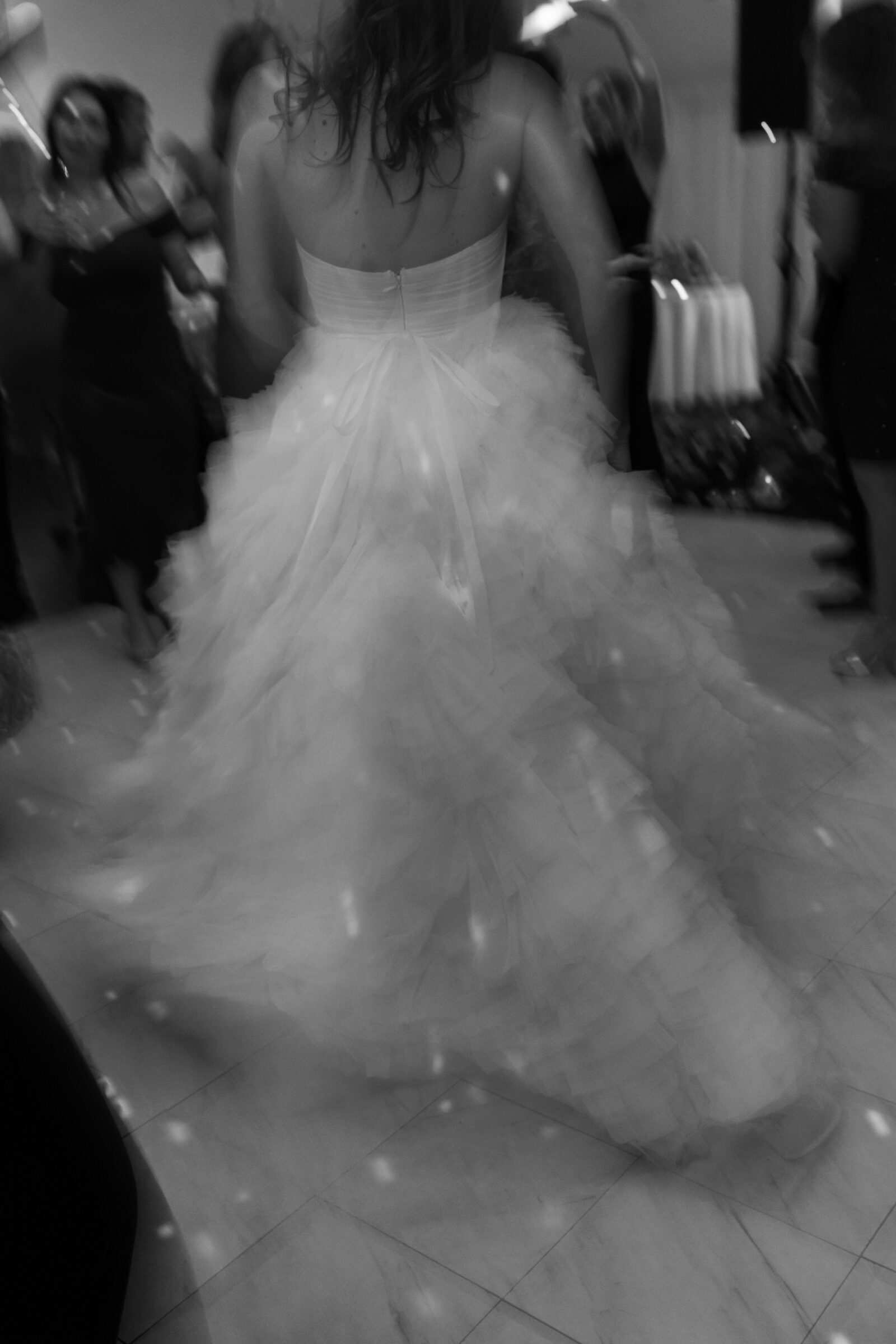 Bride twirling on the dance floor during a wedding reception in Richmond VA, with her layered gown flowing in motion.