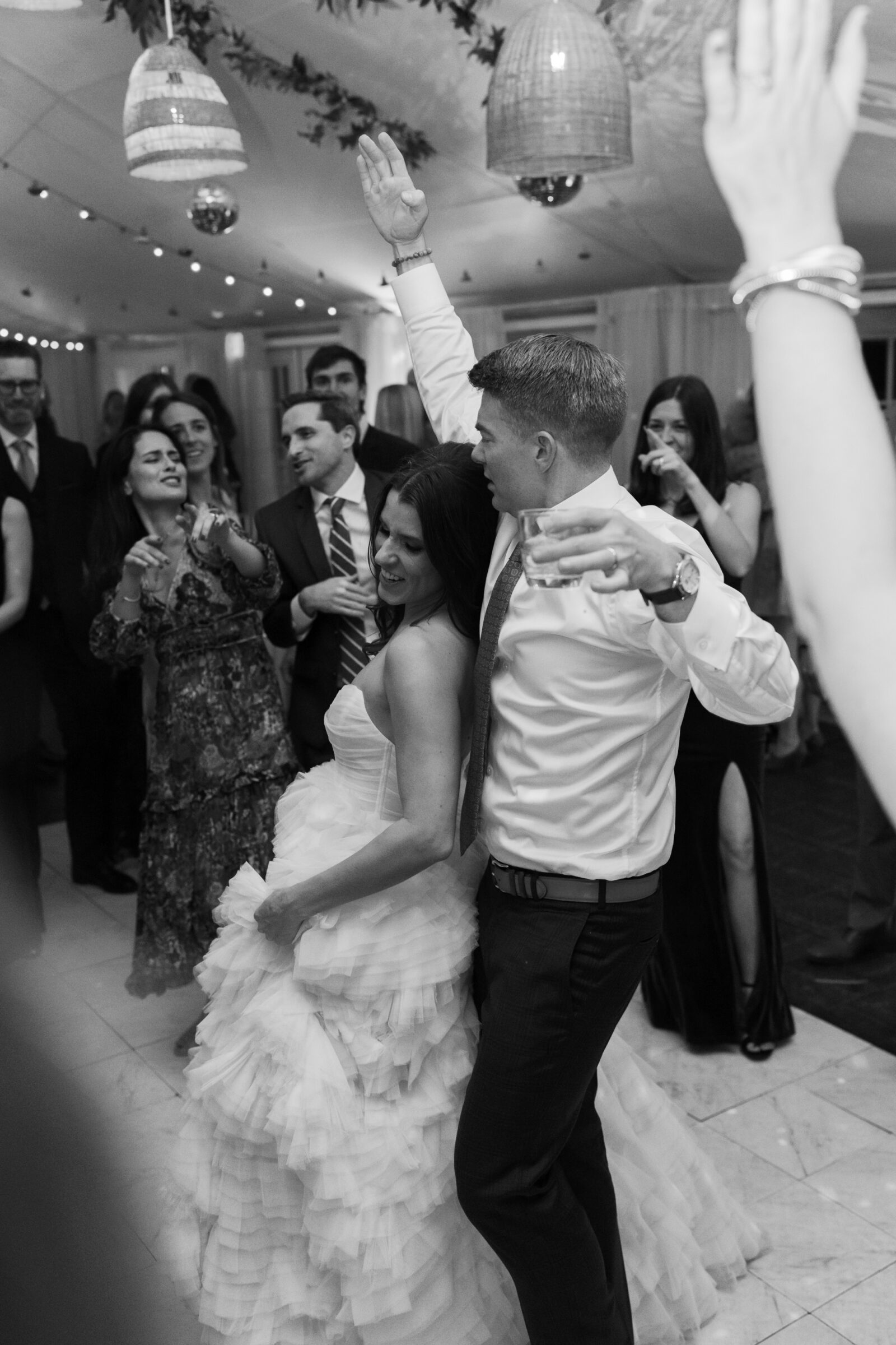 Bride and groom dancing with guests during their Mankin Mansion wedding reception in Richmond VA, celebrating under string lights and hanging lanterns.