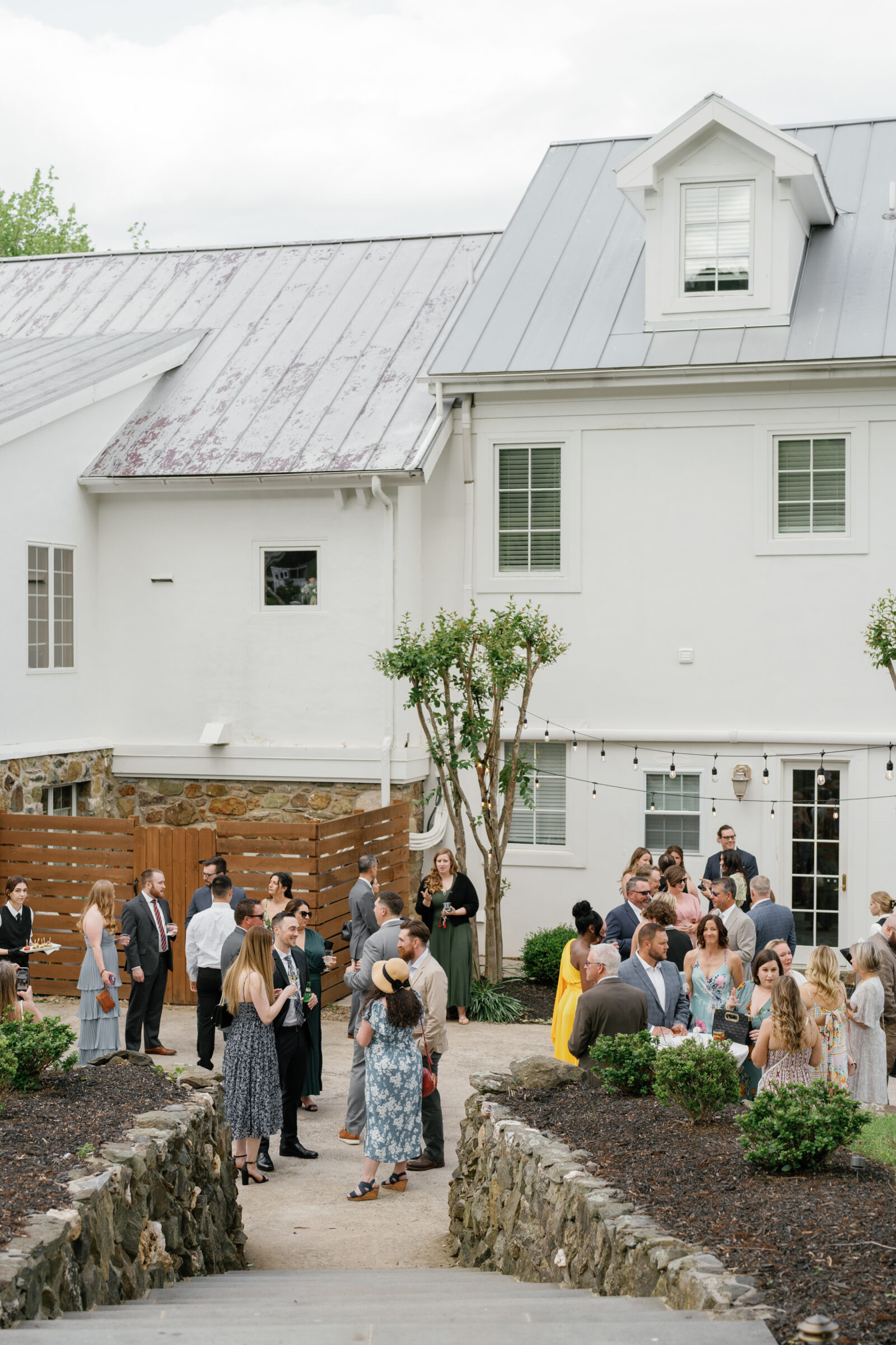 Cocktail hour at The View at Bluemont, a Northern VA wedding venue, with guests mingling outdoors by the estate during a wedding reception.