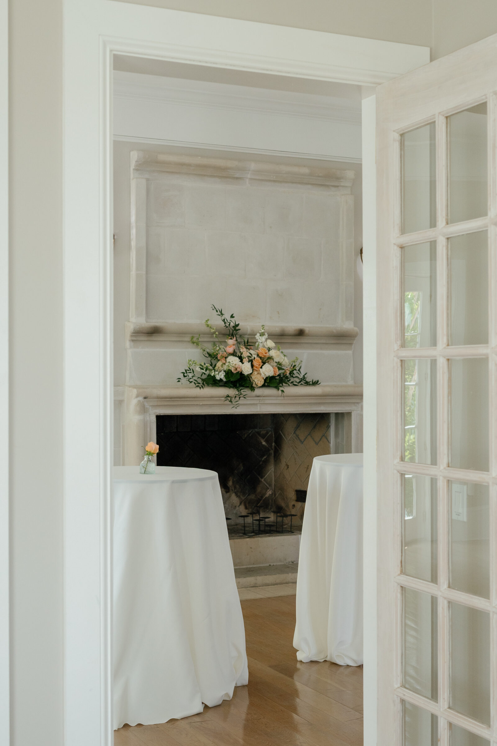 Indoor cocktail hour setup at The View at Bluemont, a Northern VA wedding venue, featuring floral arrangements and cocktail tables by the fireplace.
