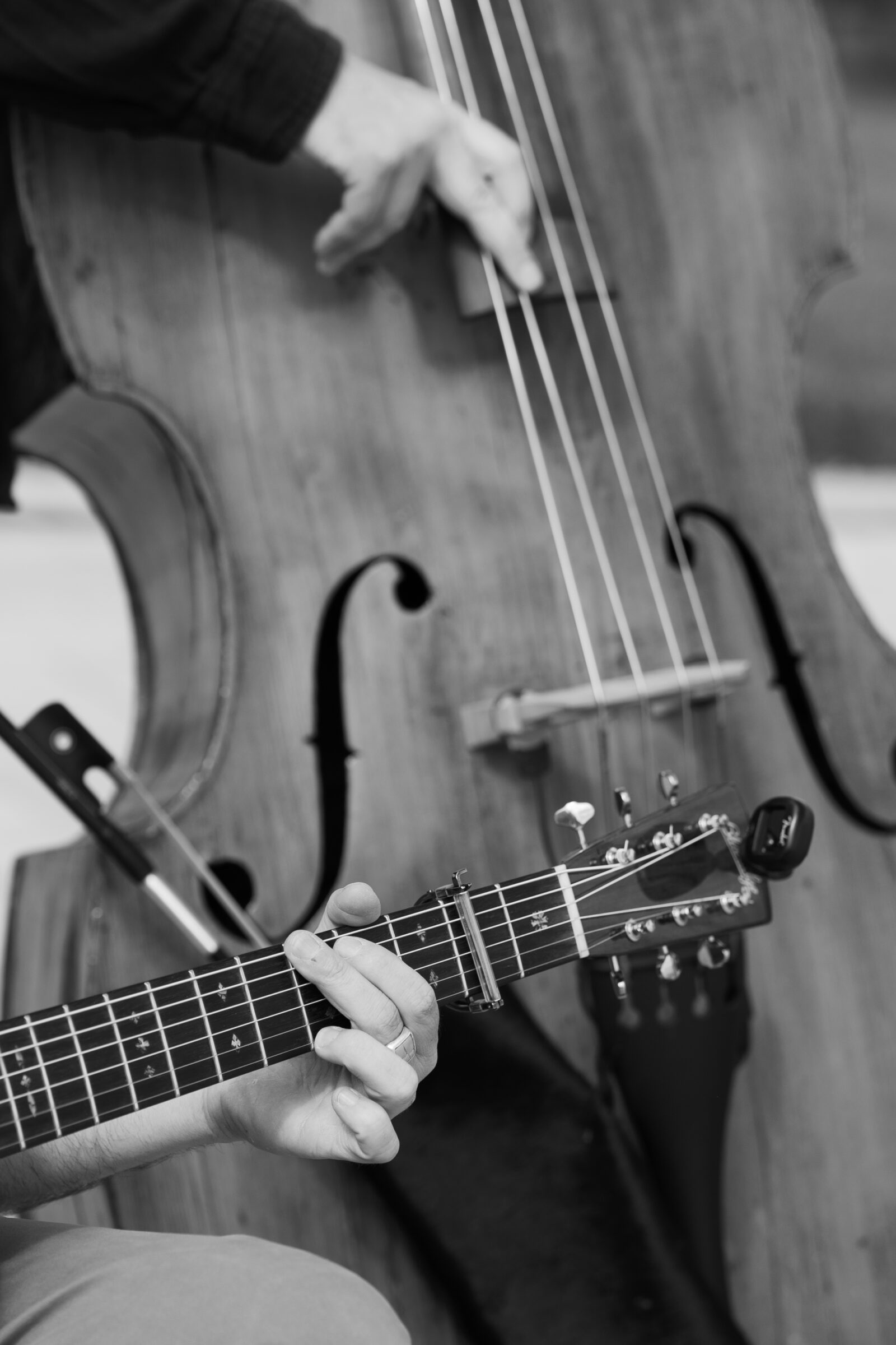 Black and white detail of live musicians playing acoustic guitar and upright bass during a wedding ceremony in Northern VA.
