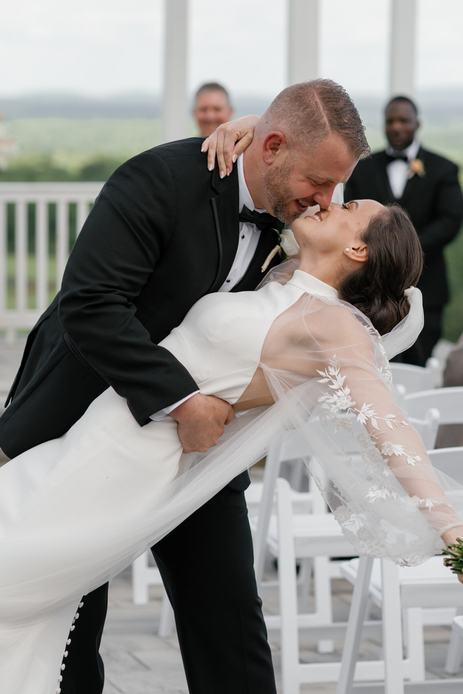 Groom dipping the bride into a romantic kiss after their ceremony on the Grand Patio at The View at Bluemont, a Northern VA wedding venue.