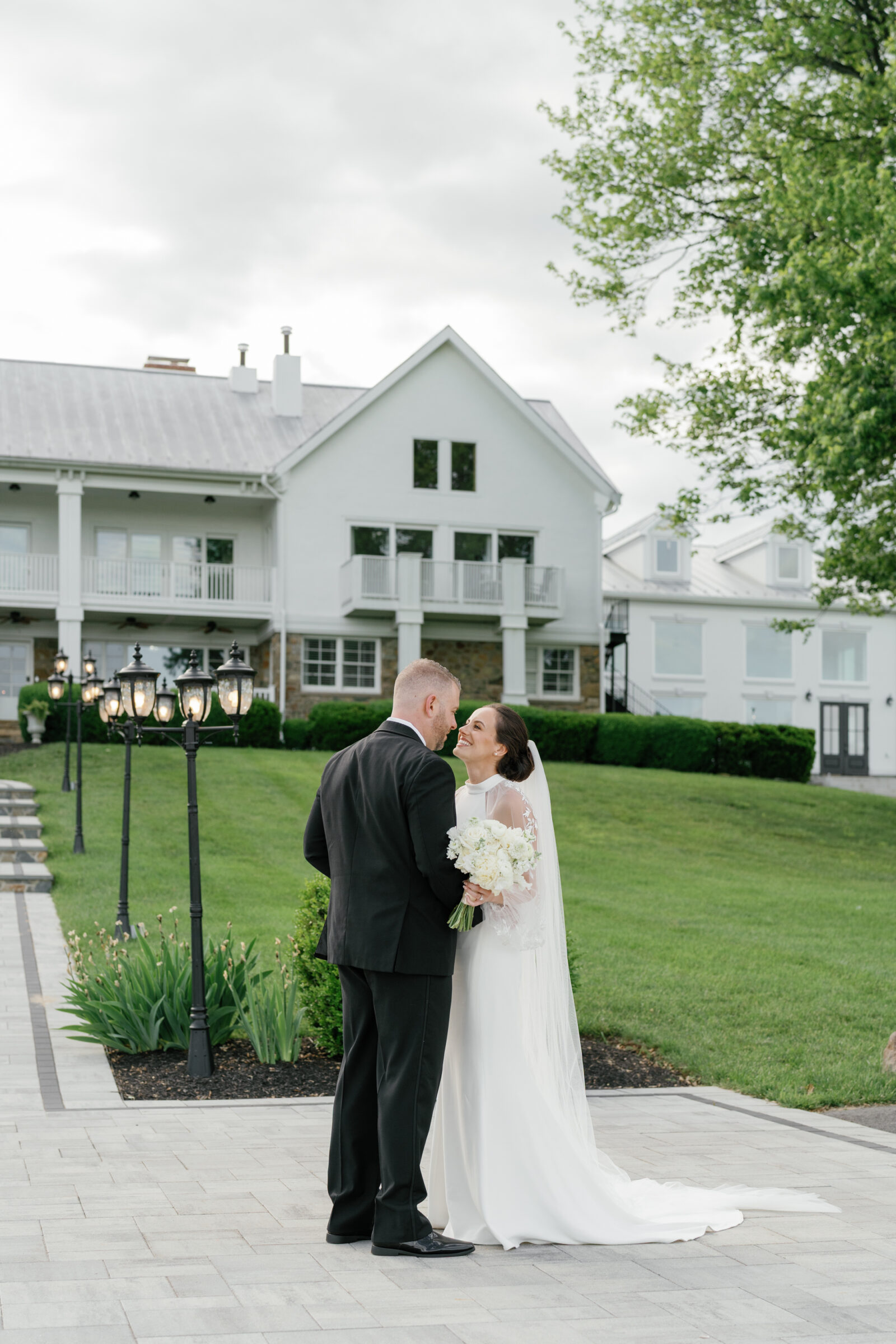 Bride and groom sharing a sweet moment outside The View at Bluemont, a classic Northern Virginia wedding venue with white manor house backdrop and romantic garden details.