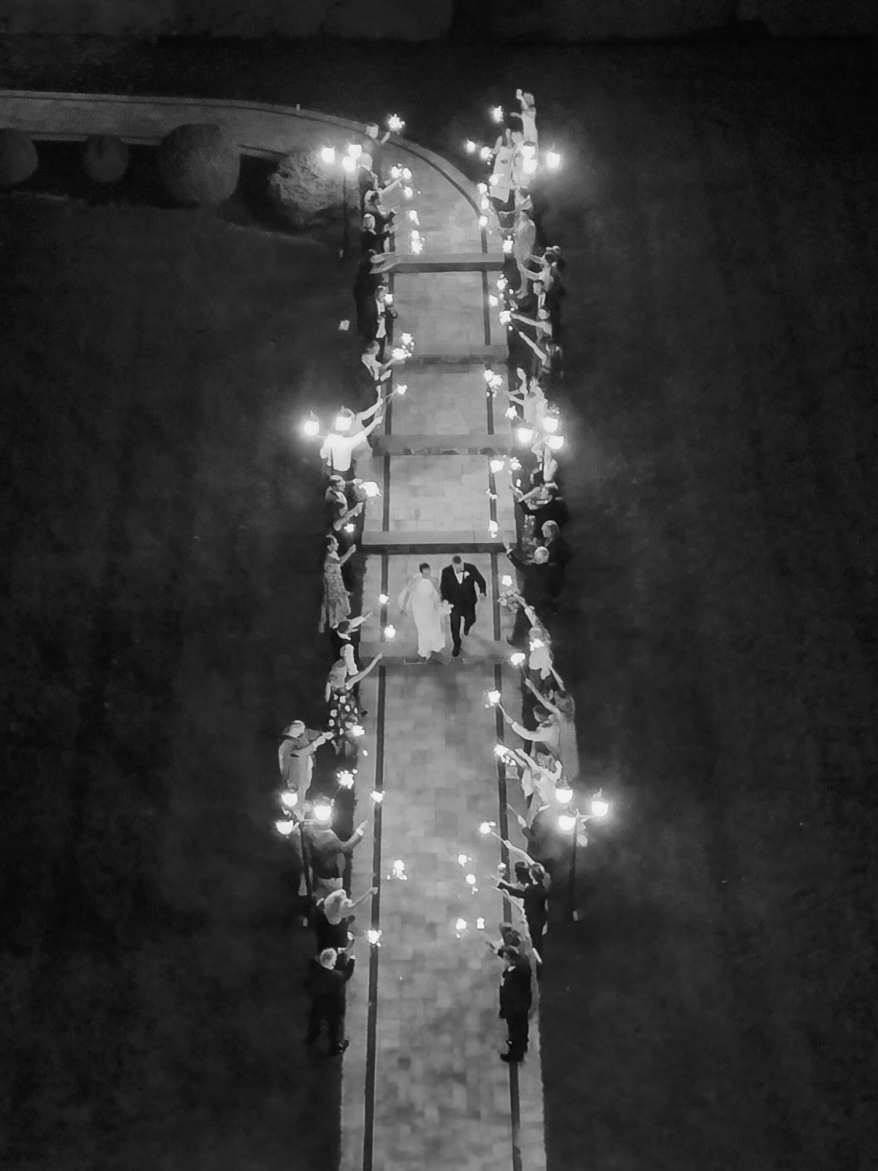 Aerial view of a sparkler send-off at The View at Bluemont, with wedding guests lining the pathway as the bride and groom walk hand in hand.