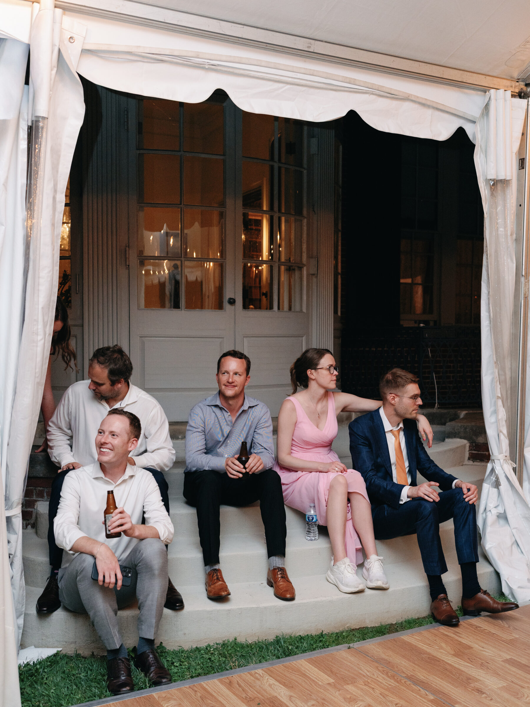 Wedding guests relaxing on the steps of the Woodrow Wilson House tented reception in Georgetown DC.