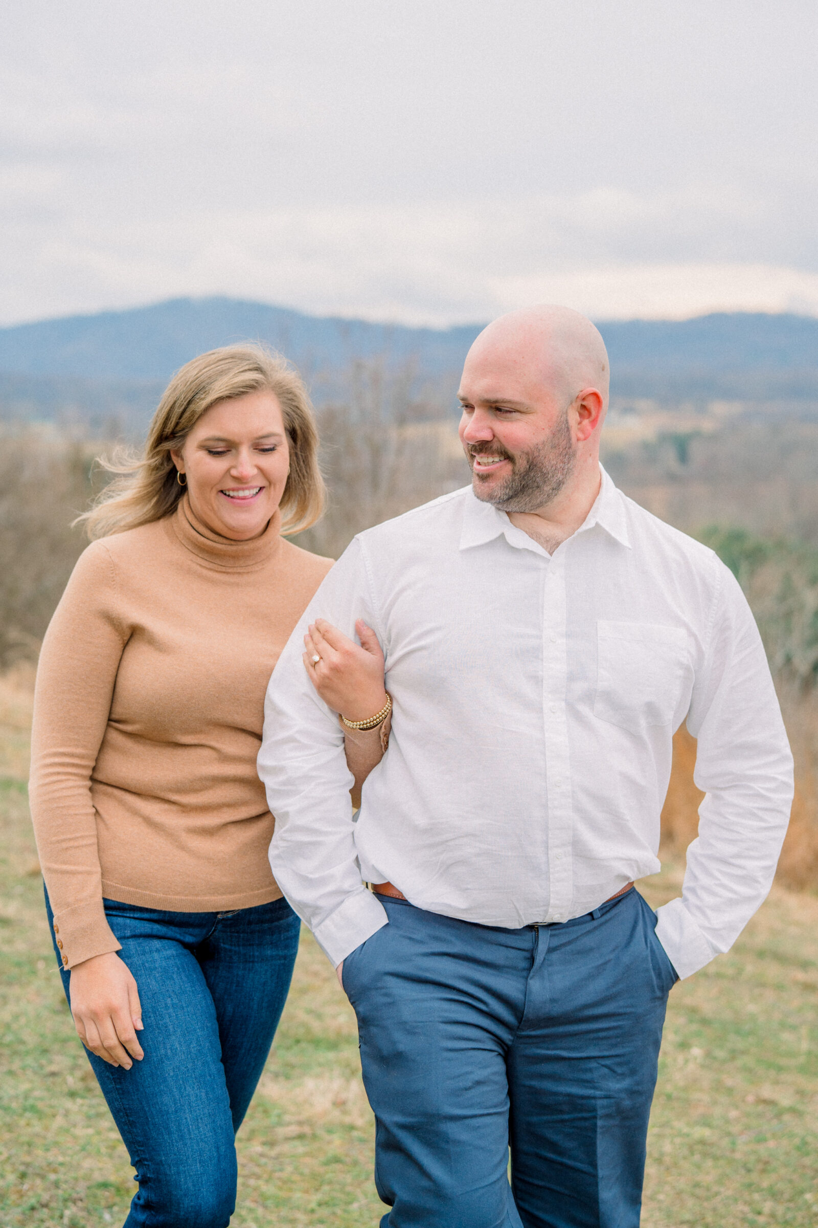 Couple walking arm in arm with mountain views in the background