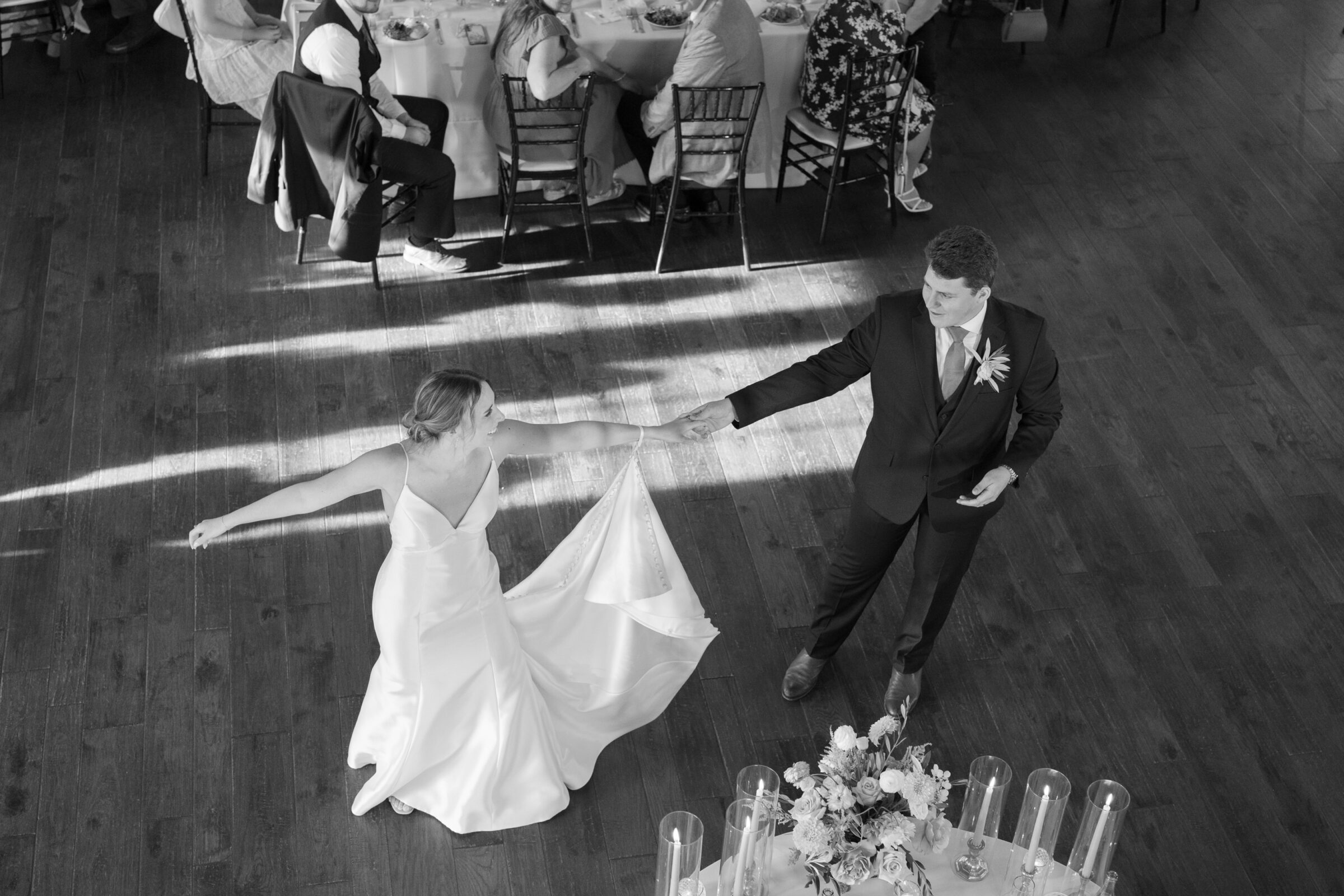 Black and white photo of bride and groom sharing their first dance on the wooden floor of the ballroom at Burlington Weddings & Events in Charles City VA.