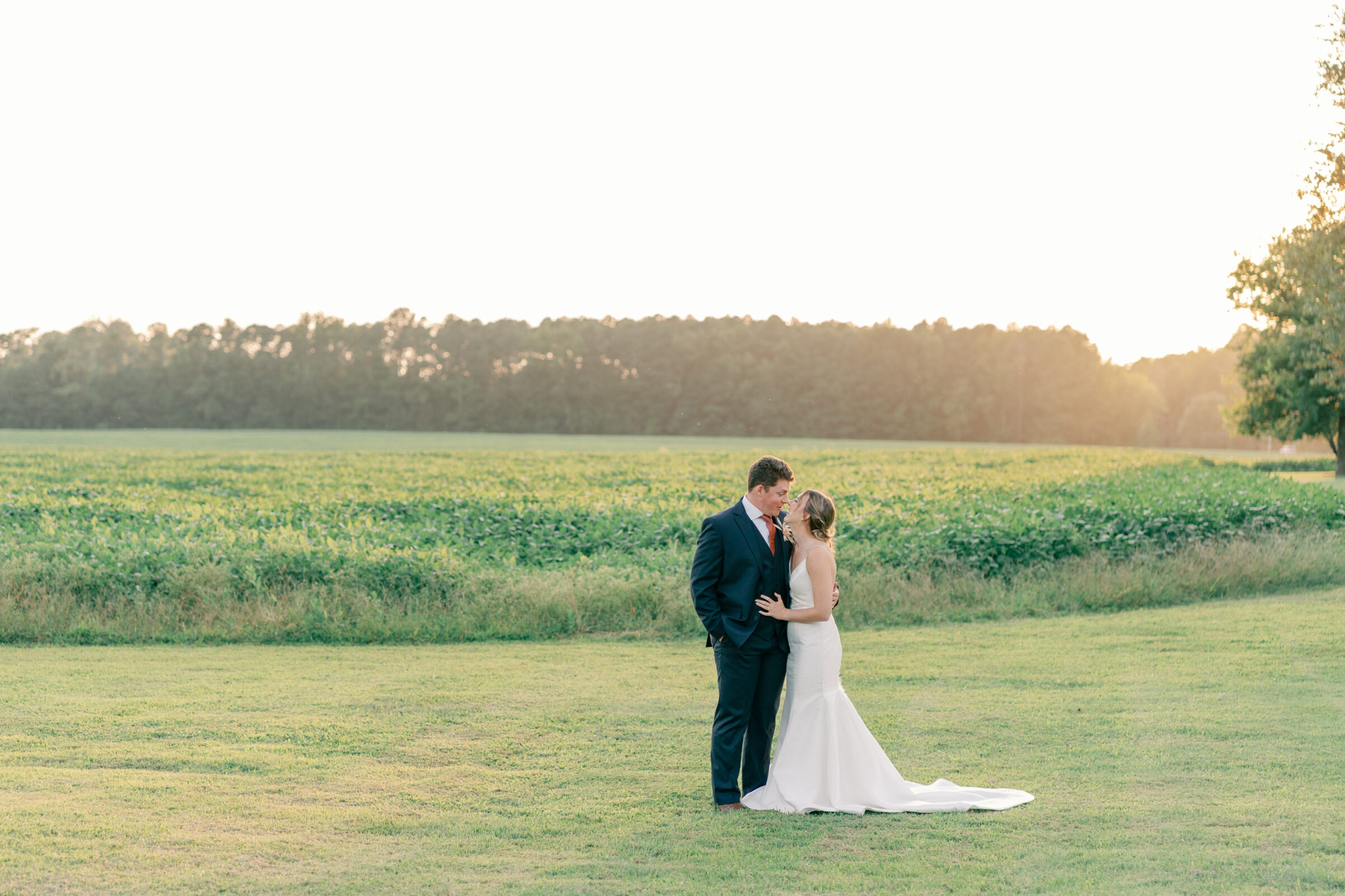 Bride and groom sharing a romantic moment at golden hour in the open fields at Burlington Weddings & Events in Charles City VA.