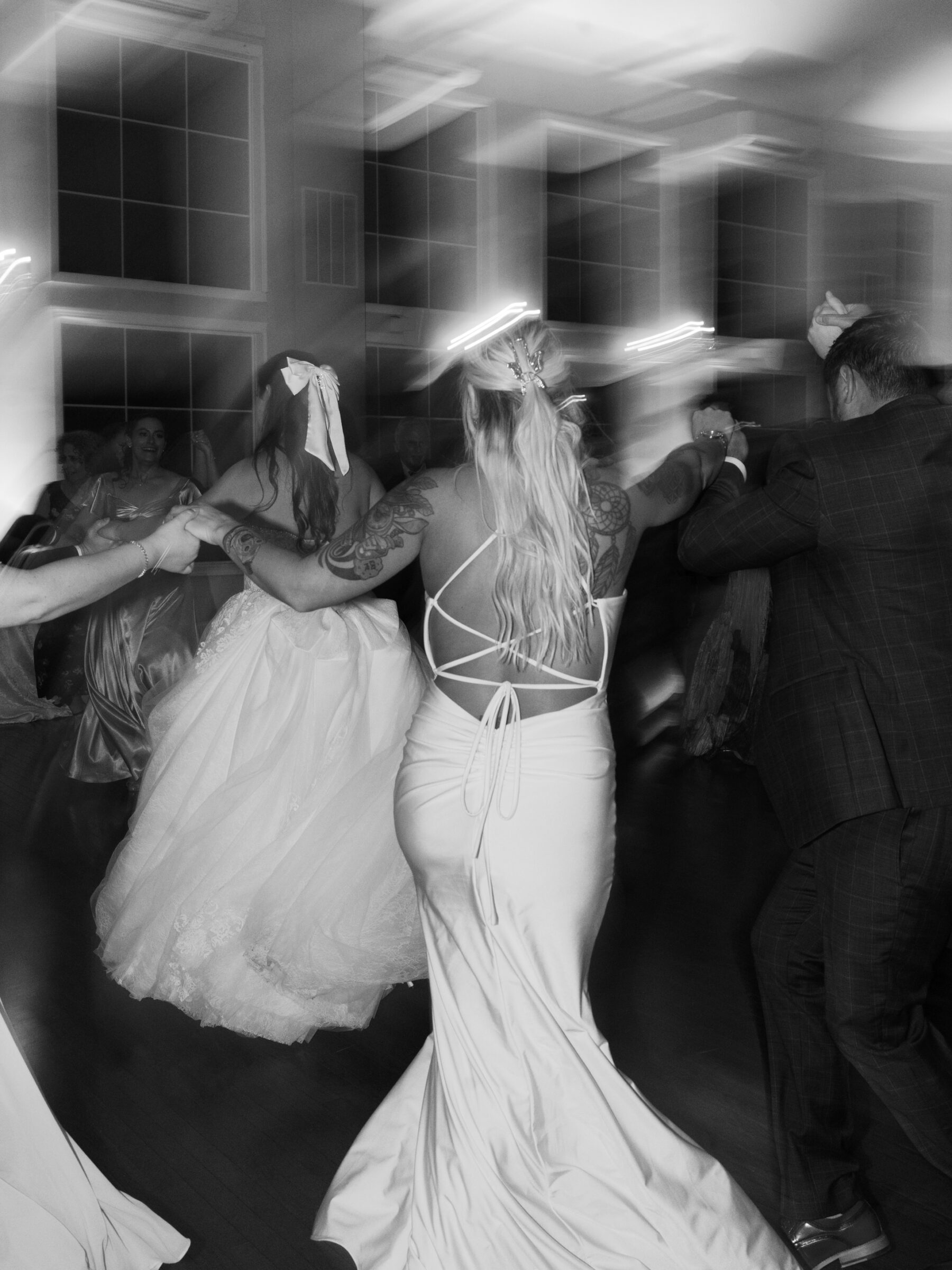 Guests dancing the horah in a circle around the bride during a Jewish wedding celebration.