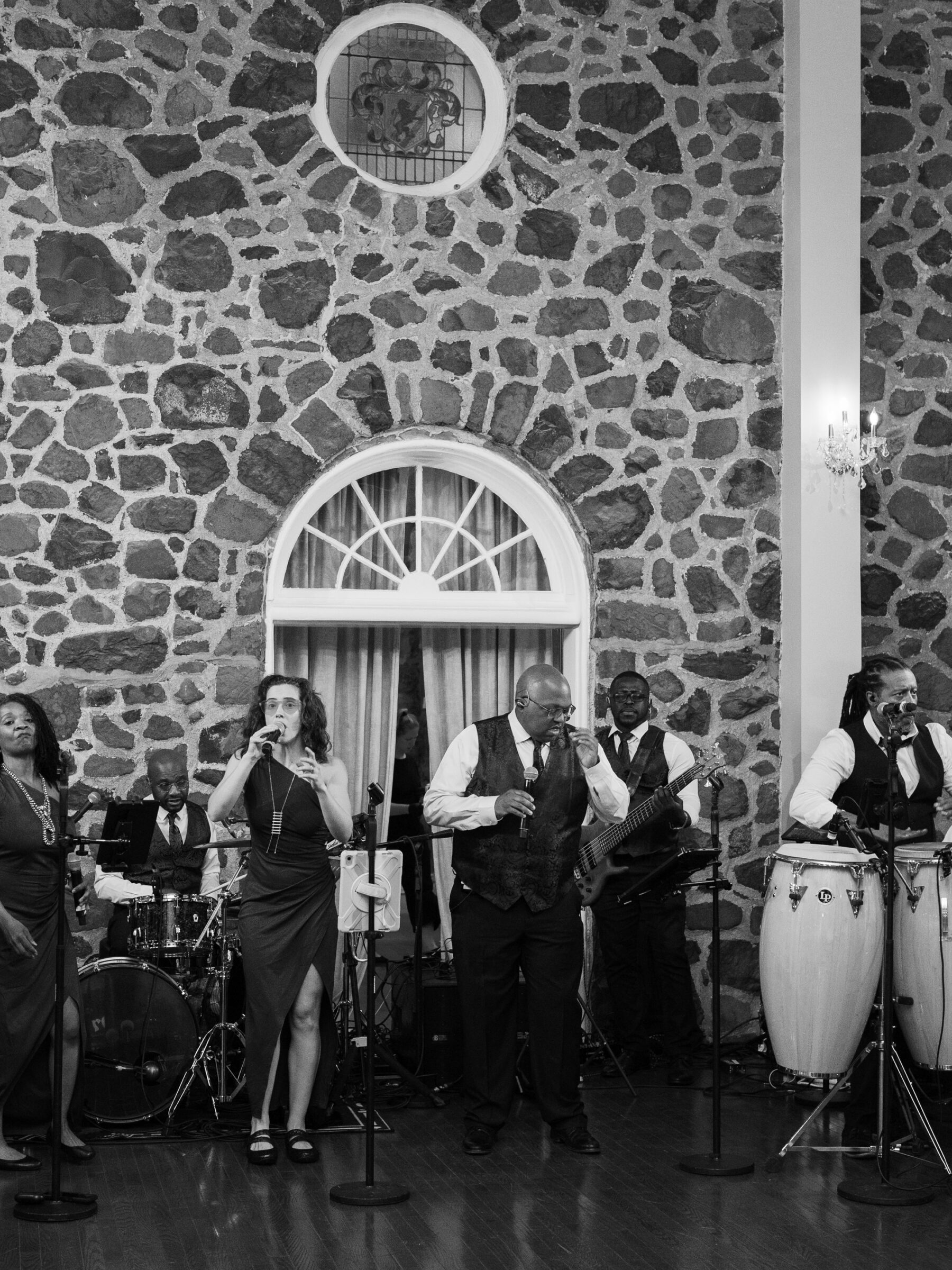 Live band performing, set against the stone walls of the elegant ballroom.