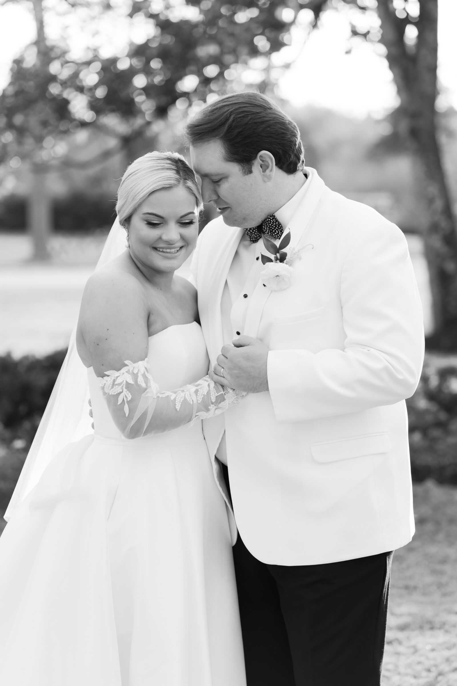 Black and white portrait of the bride and groom embracing during their Williamsburg Inn wedding, sharing a quiet and romantic moment together.