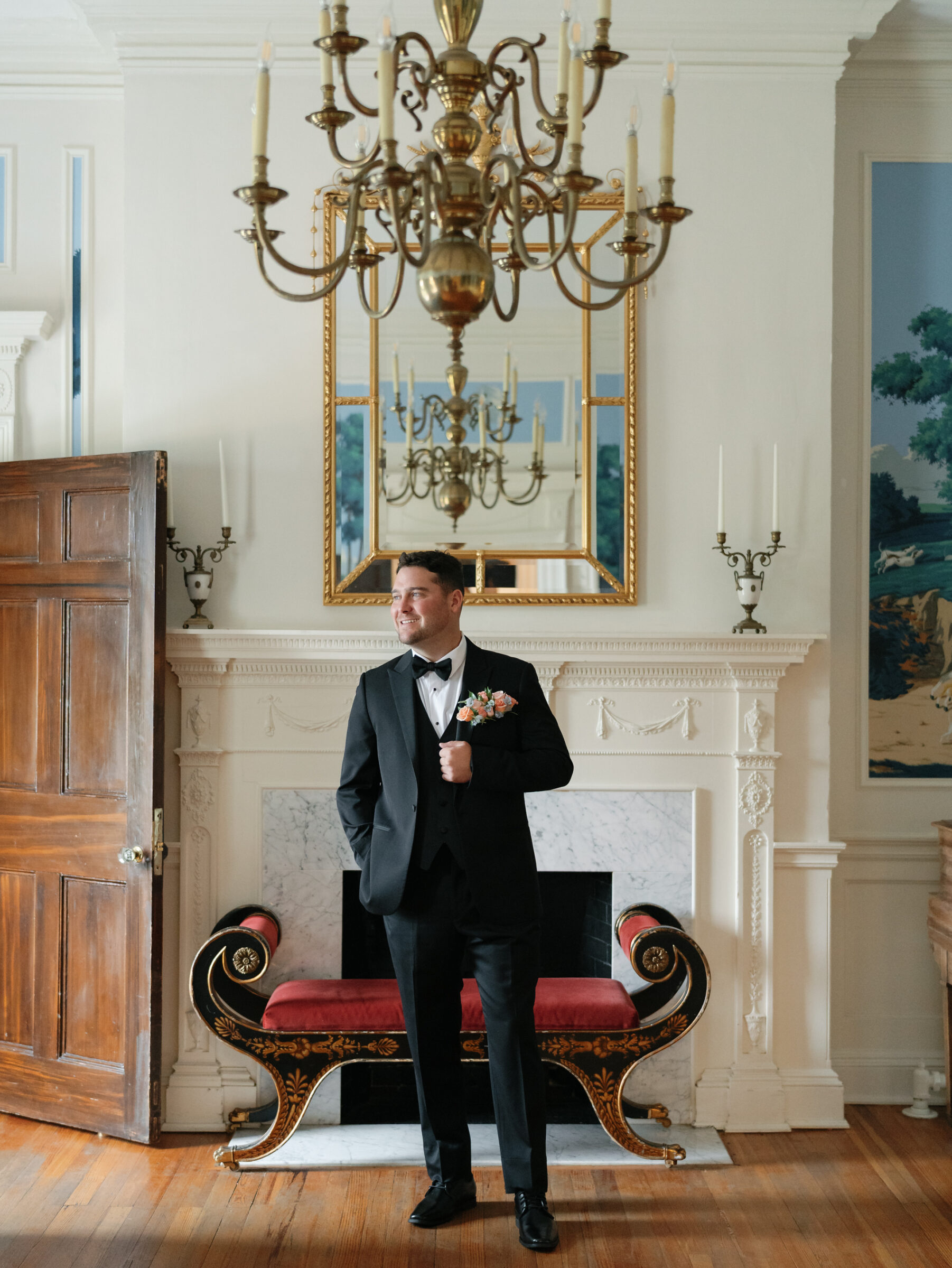 Groom in a black tuxedo standing in the historic manor house at Belmont Country Club in Ashburn, VA.