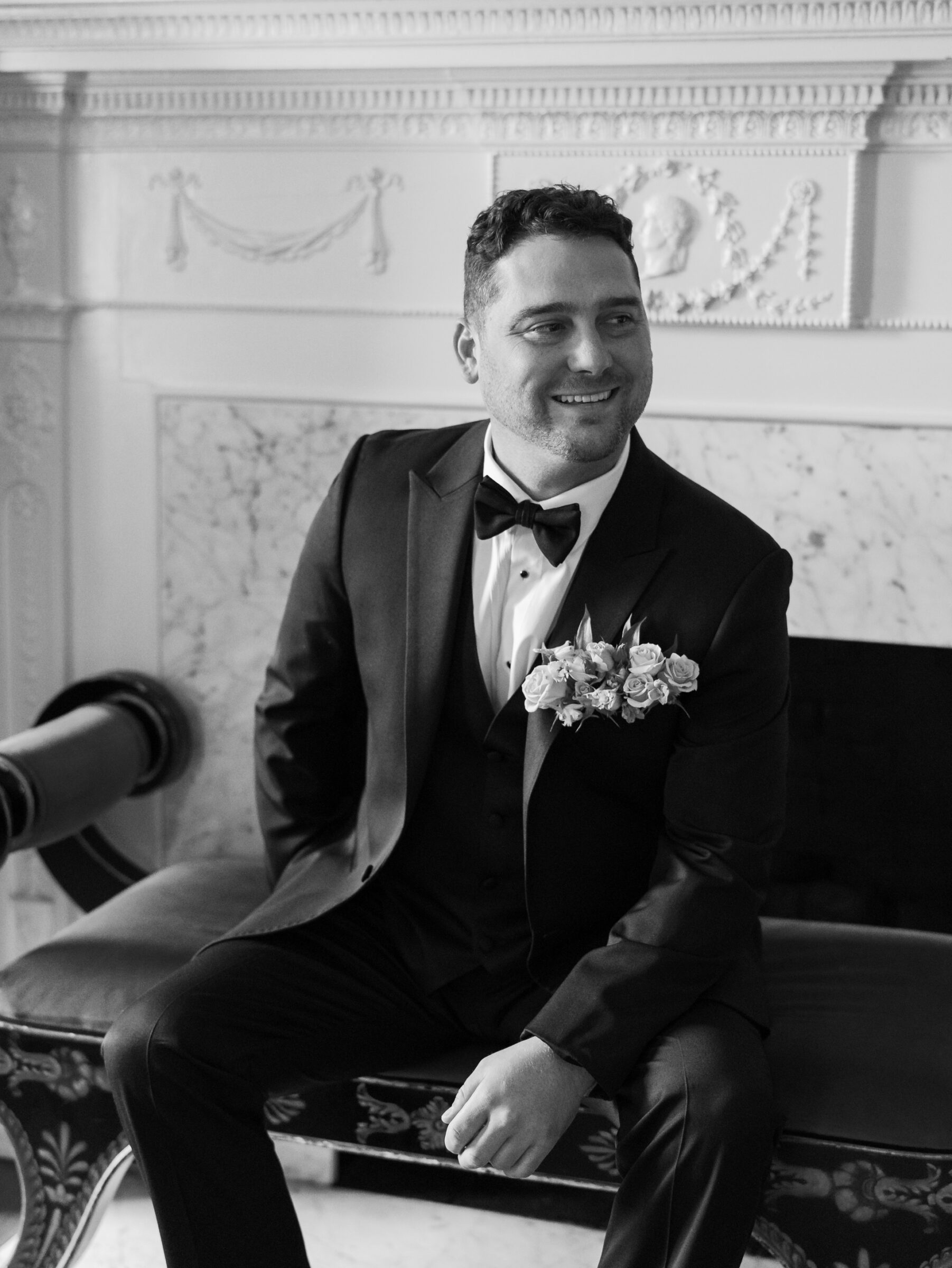 Groom smiling while seated in the historic manor house at Belmont Country Club in Ashburn, VA.