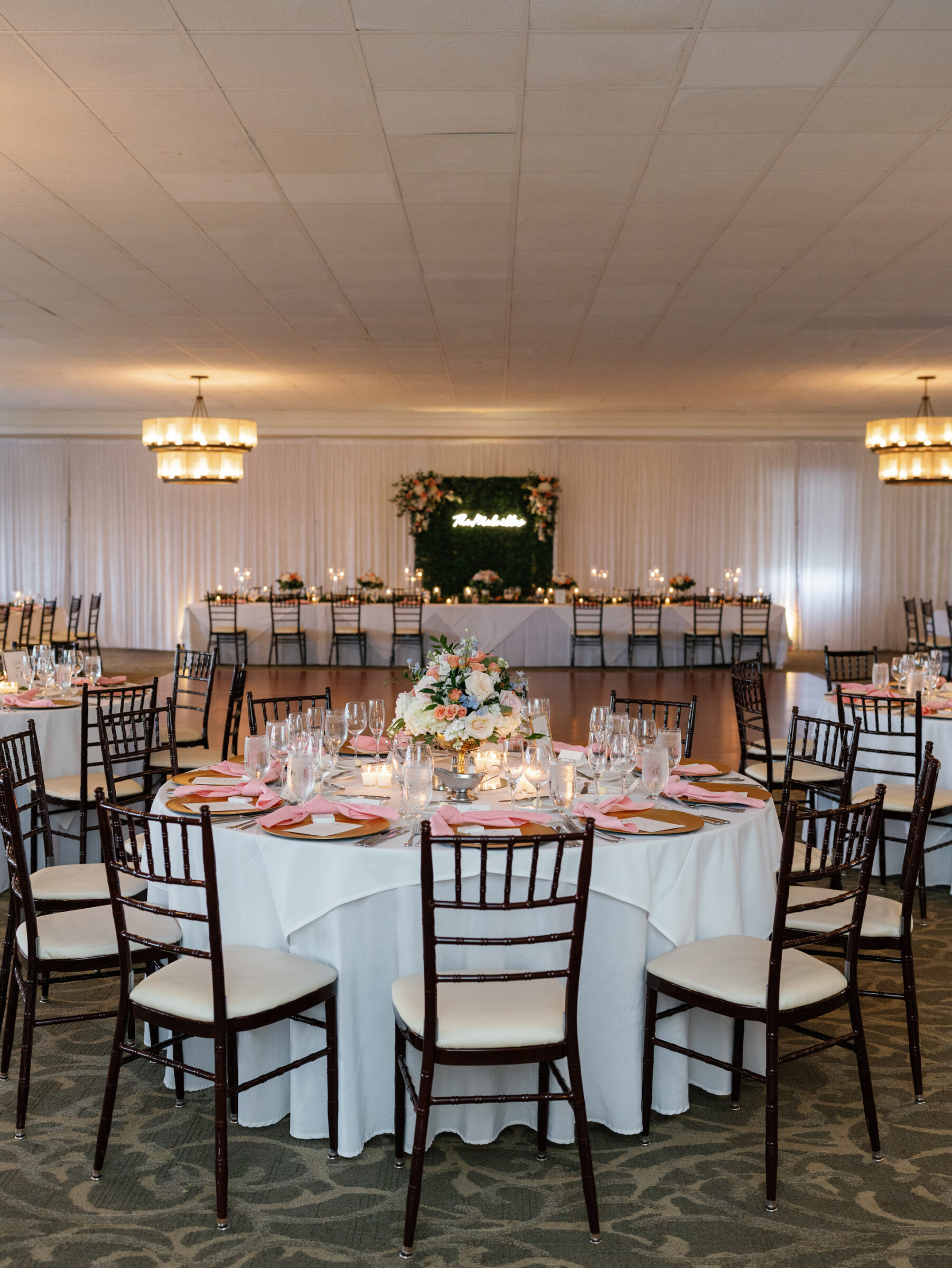 Elegant wedding reception setup with round tables, floral centerpieces, and sweetheart table in the Grand Ballroom at Belmont Country Club in Ashburn, VA.