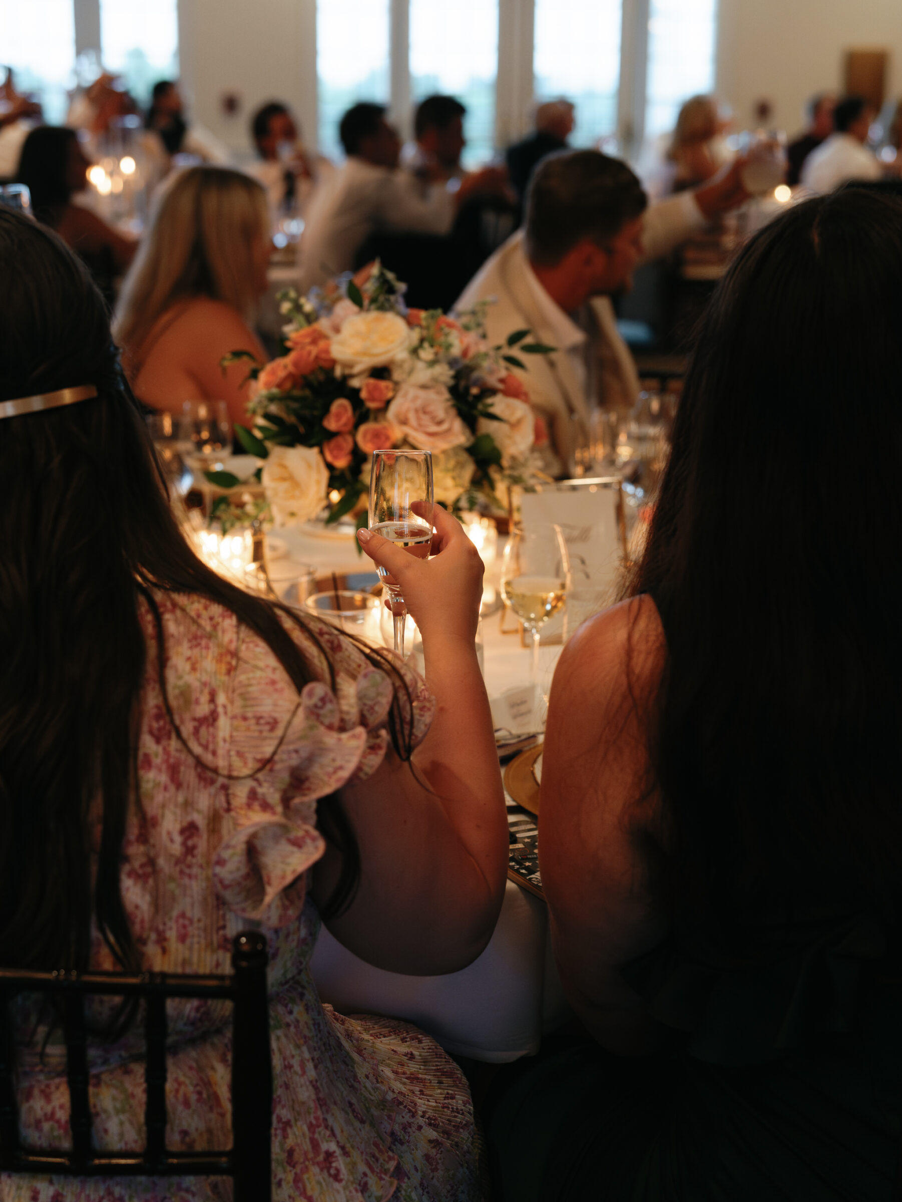 Wedding guests raising glasses for a toast during the reception