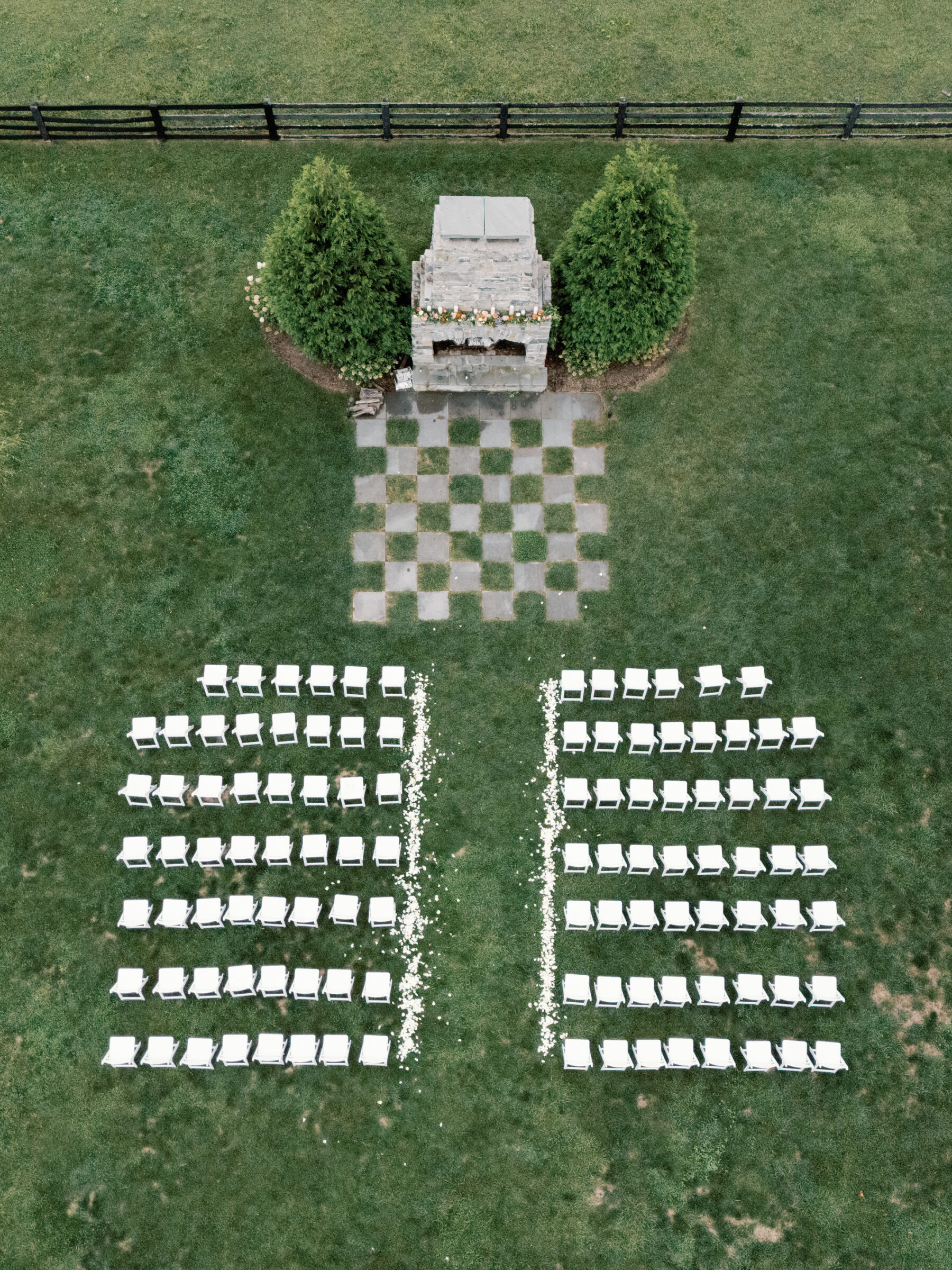 Outdoor ceremony setup with white chairs and stone fireplace altar at Red August Farm wedding in Waynesboro VA