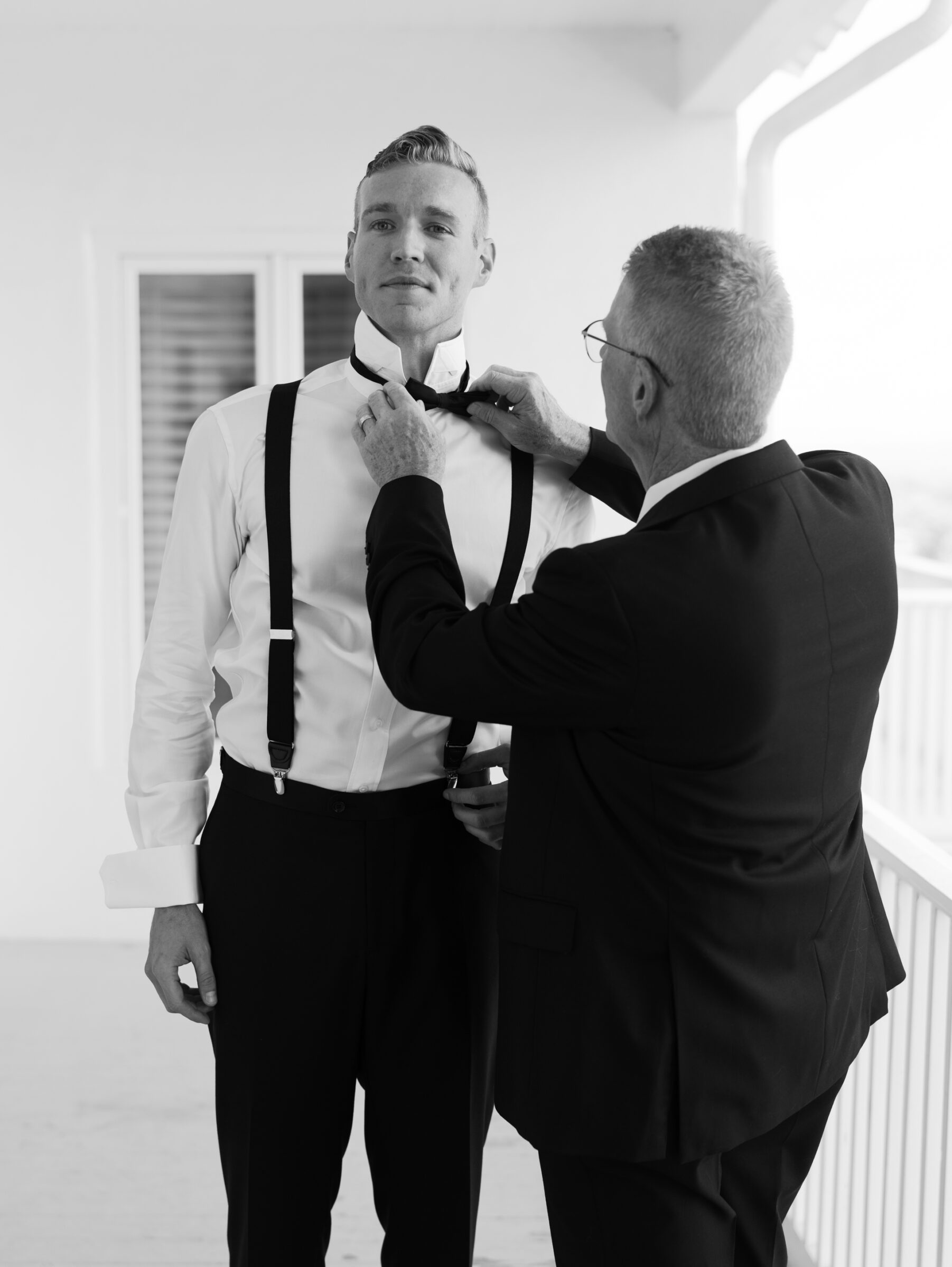 Father helping the groom with his bow tie before the ceremony during a classic The View at Bluemont Wedding in Northern Virginia.