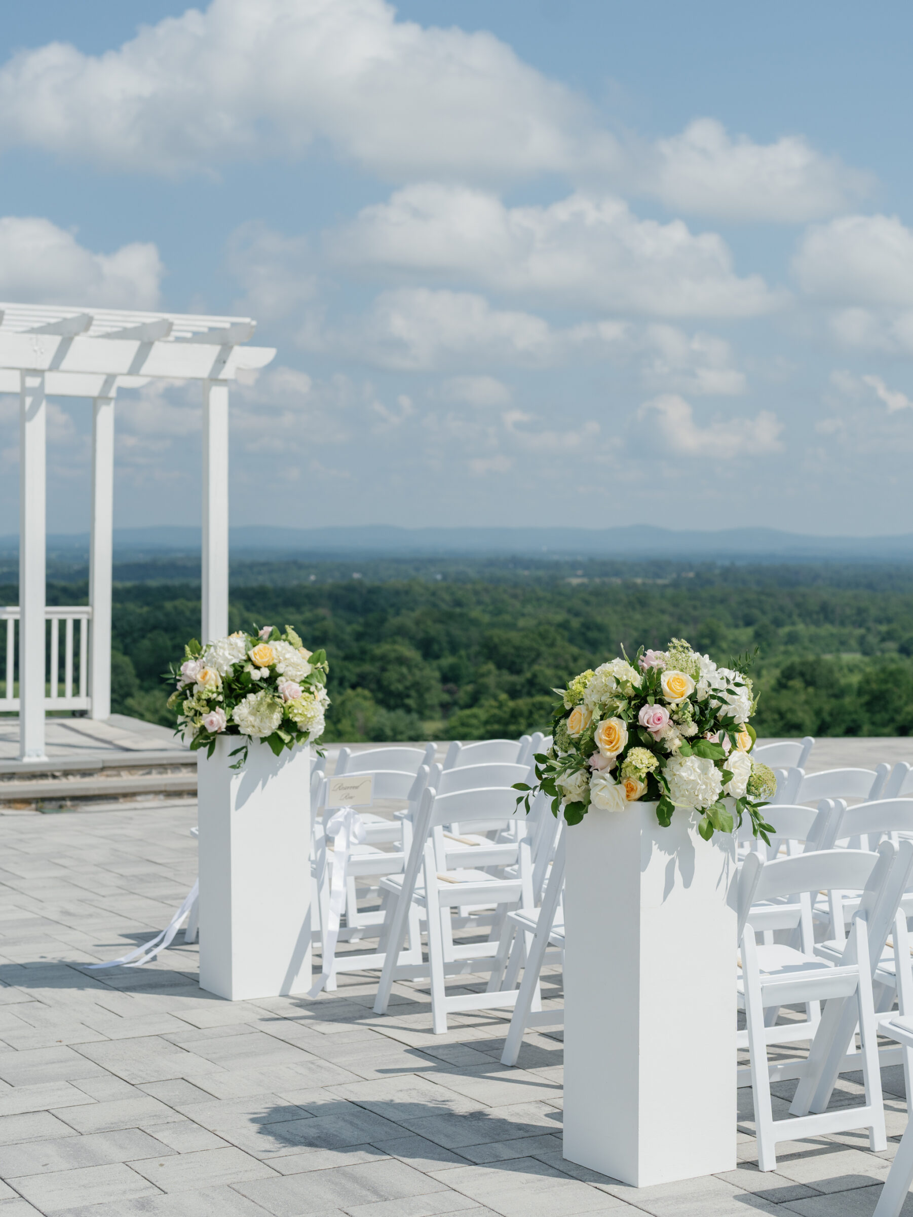 Outdoor terrace ceremony decor for a The View at Bluemont Wedding, featuring pastel floral arrangements and mountain scenery in Northern Virginia.