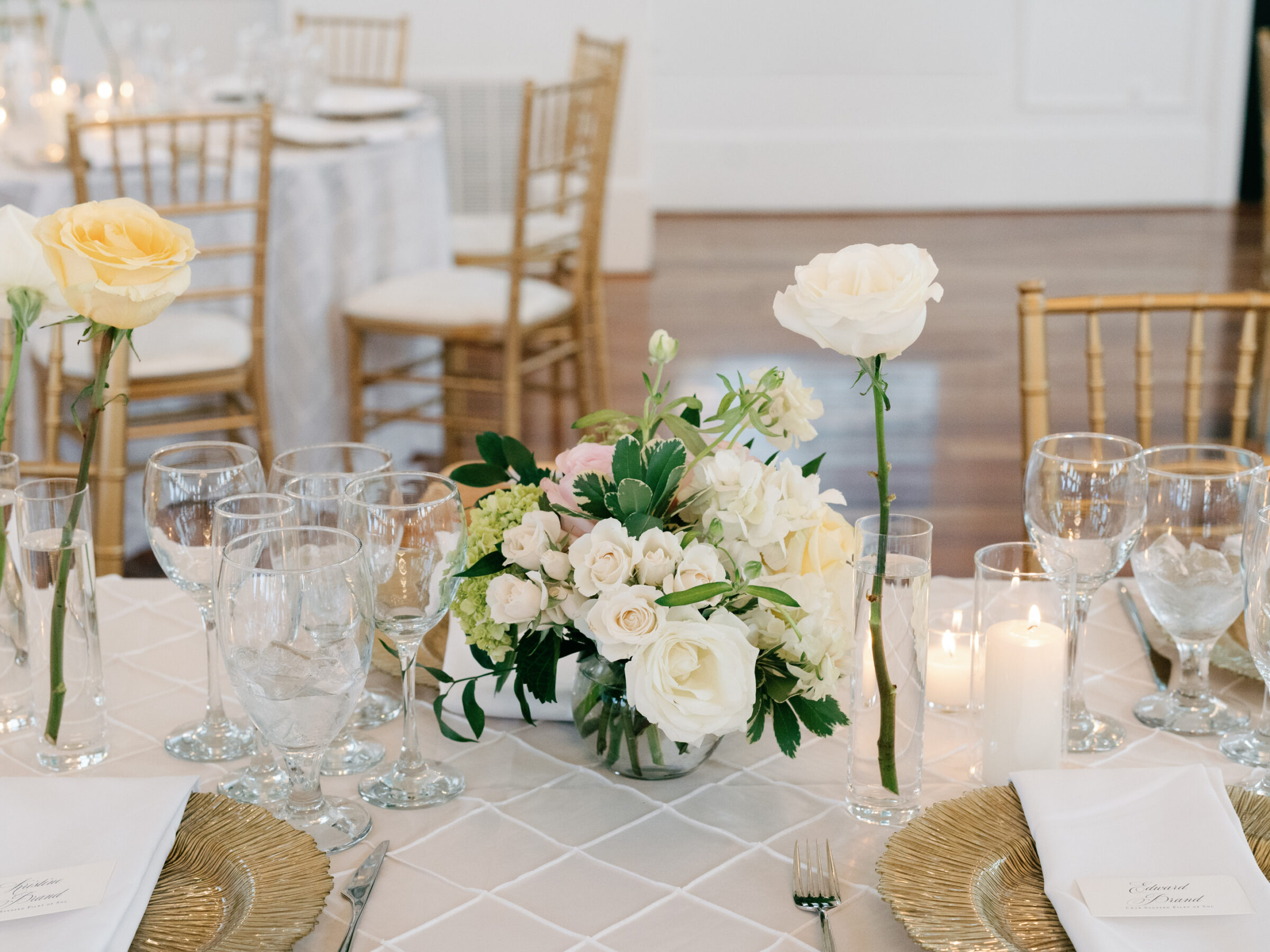 Candlelit table setting with white and yellow florals, gold accents, and glassware at a timeless The View at Bluemont Wedding in Northern Virginia.