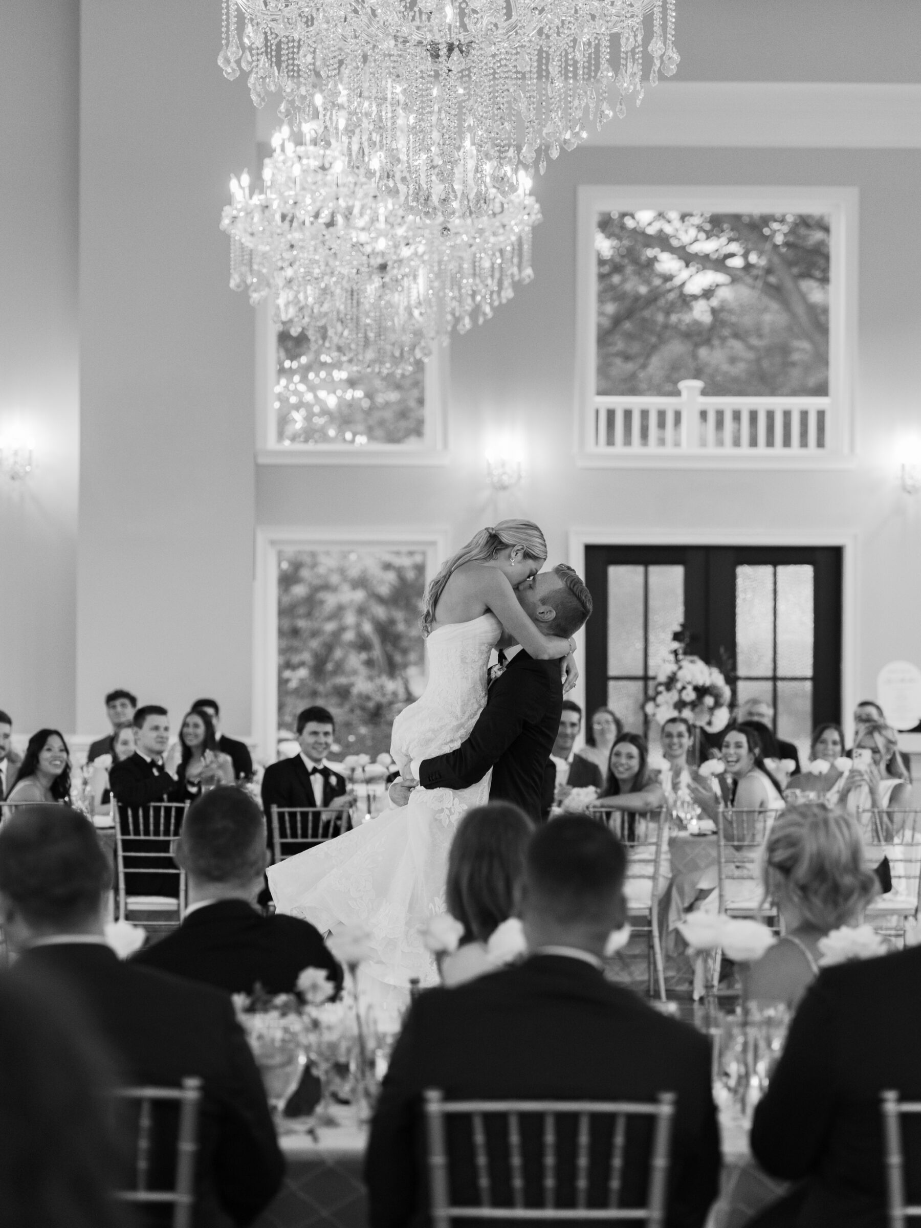 A joyful first dance moment under sparkling chandeliers during a timeless The View at Bluemont Wedding reception.