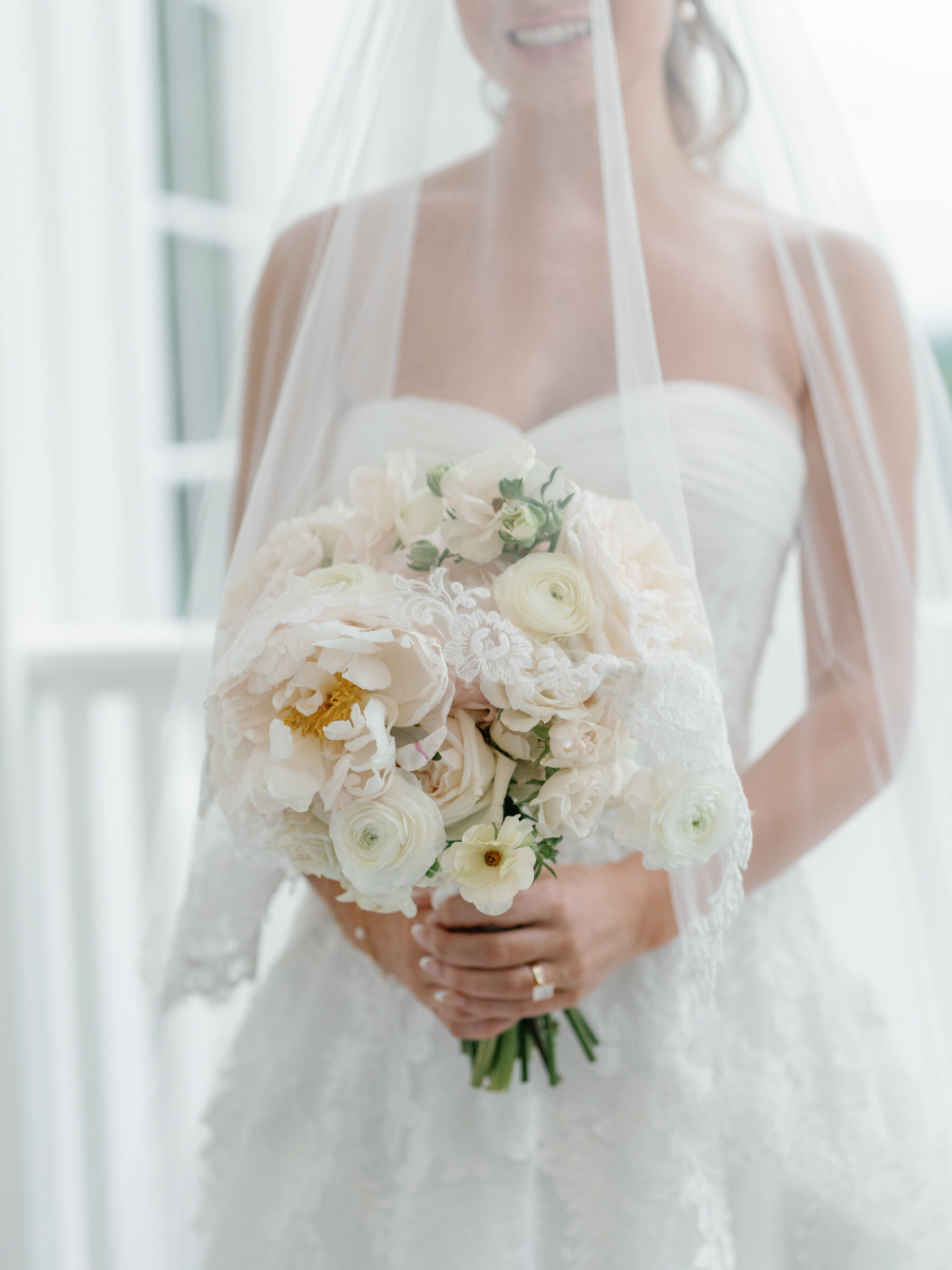 Bridal bouquet of white and blush flowers beneath a flowing veil during a classic The View at Bluemont Wedding in Northern Virginia.
