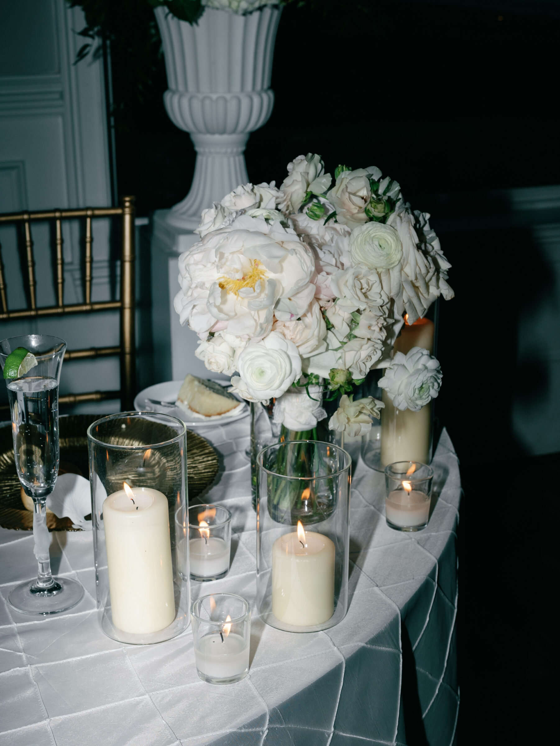 Candlelit wedding reception table decor at The View at Bluemont with white floral centerpiece and gold place settings.