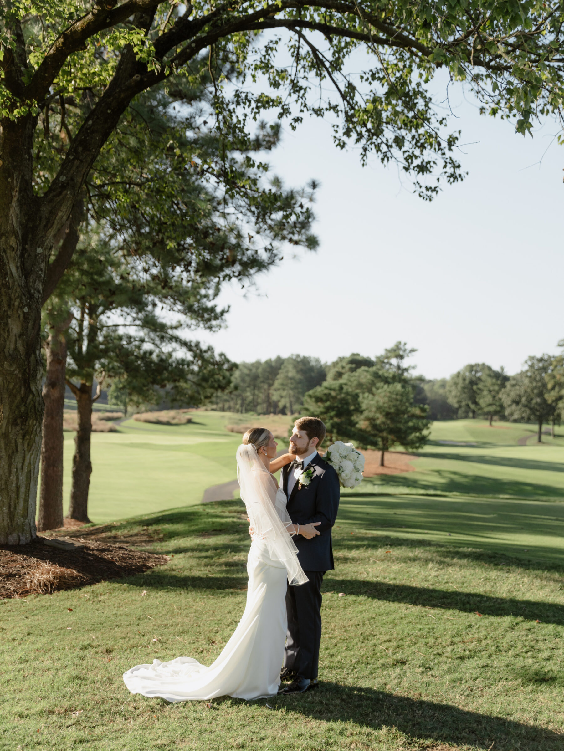Hermitage Country Club Wedding | Bride and groom standing together on the golf course, sharing a quiet moment under the trees after their ceremony.