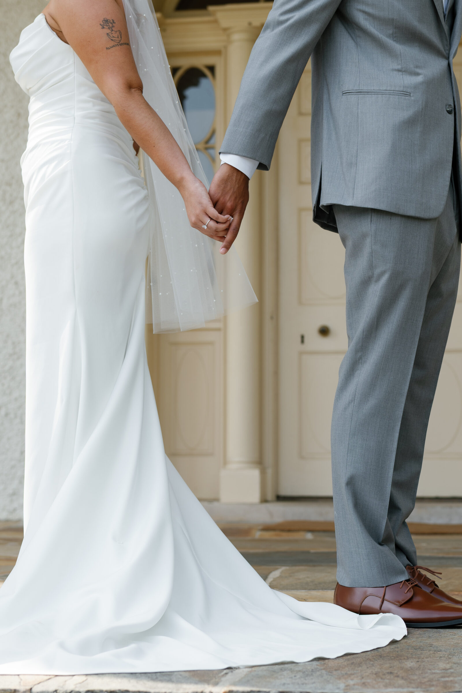 Close-up of the bride and groom holding hands during their first look outside Rust Manor House.
