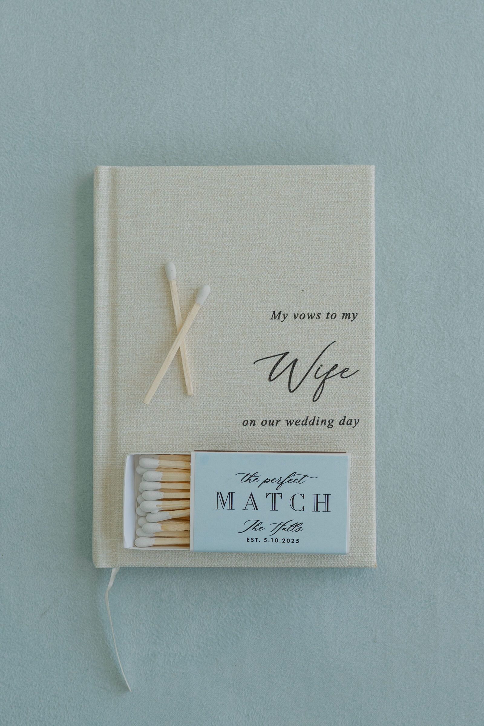 Southern MD Wedding Photographer | A groom’s vow book styled with personalized matchbox favors and loose matches, photographed in soft light for an elegant wedding flatlay.