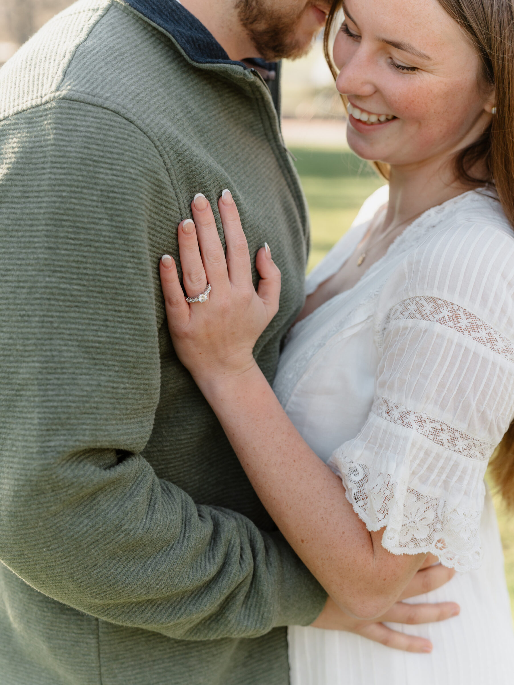 Bride showing her engagement ring while embracing her fiancé during a fall engagement session at the Biltmore Estate in Asheville NC