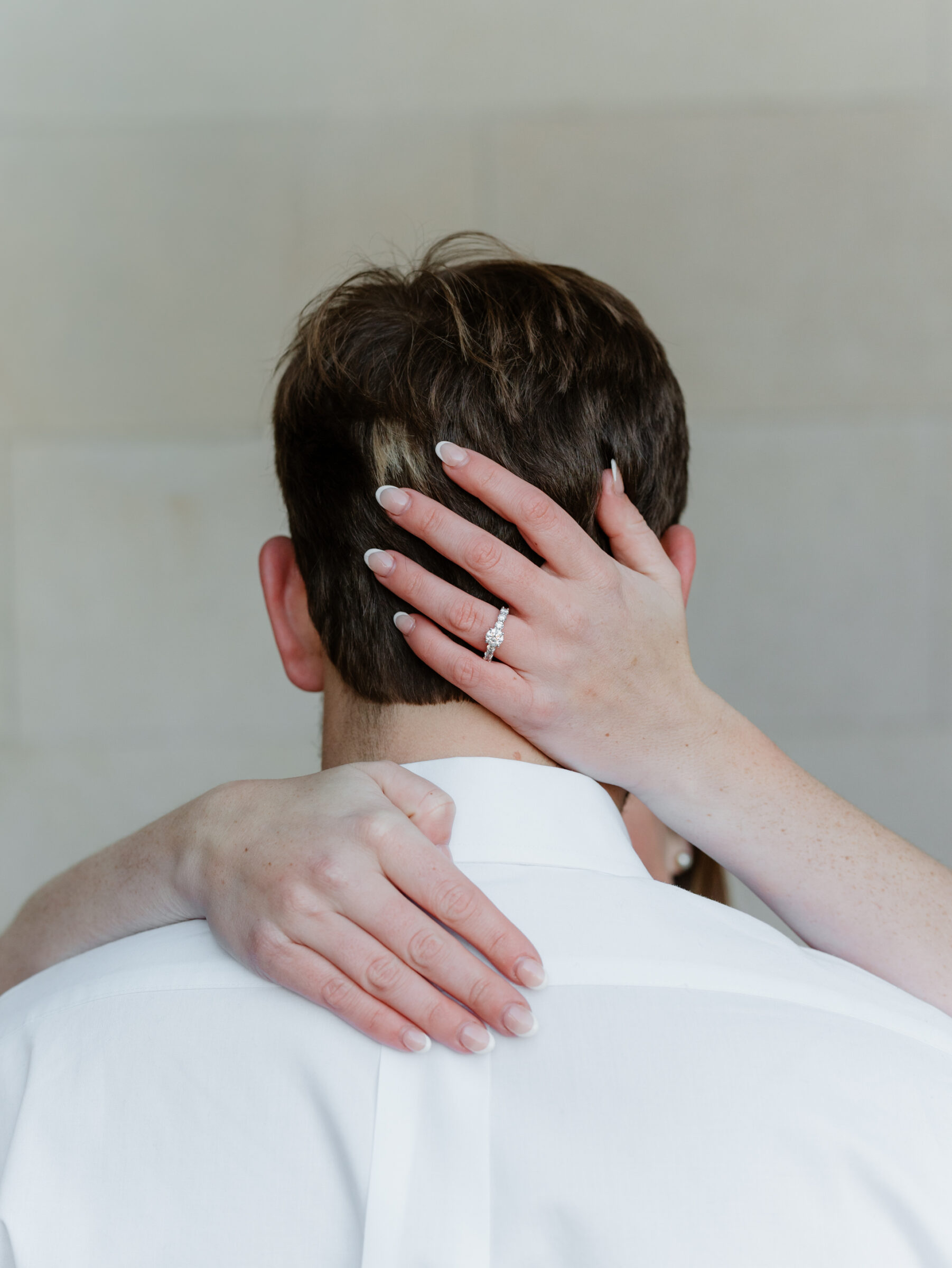 Bride showing her engagement ring while embracing her fiancé during an engagement session at the Biltmore Estate in Asheville NC