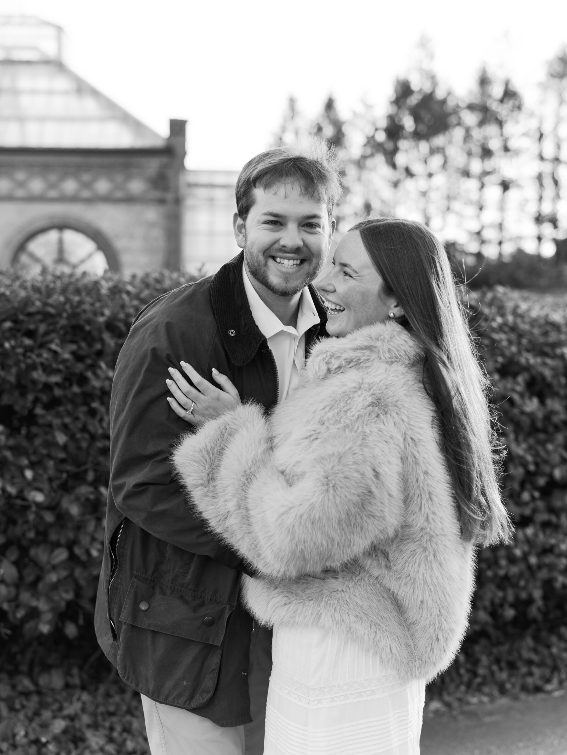 Black and white candid portrait of a couple laughing together during a joyful engagement moment