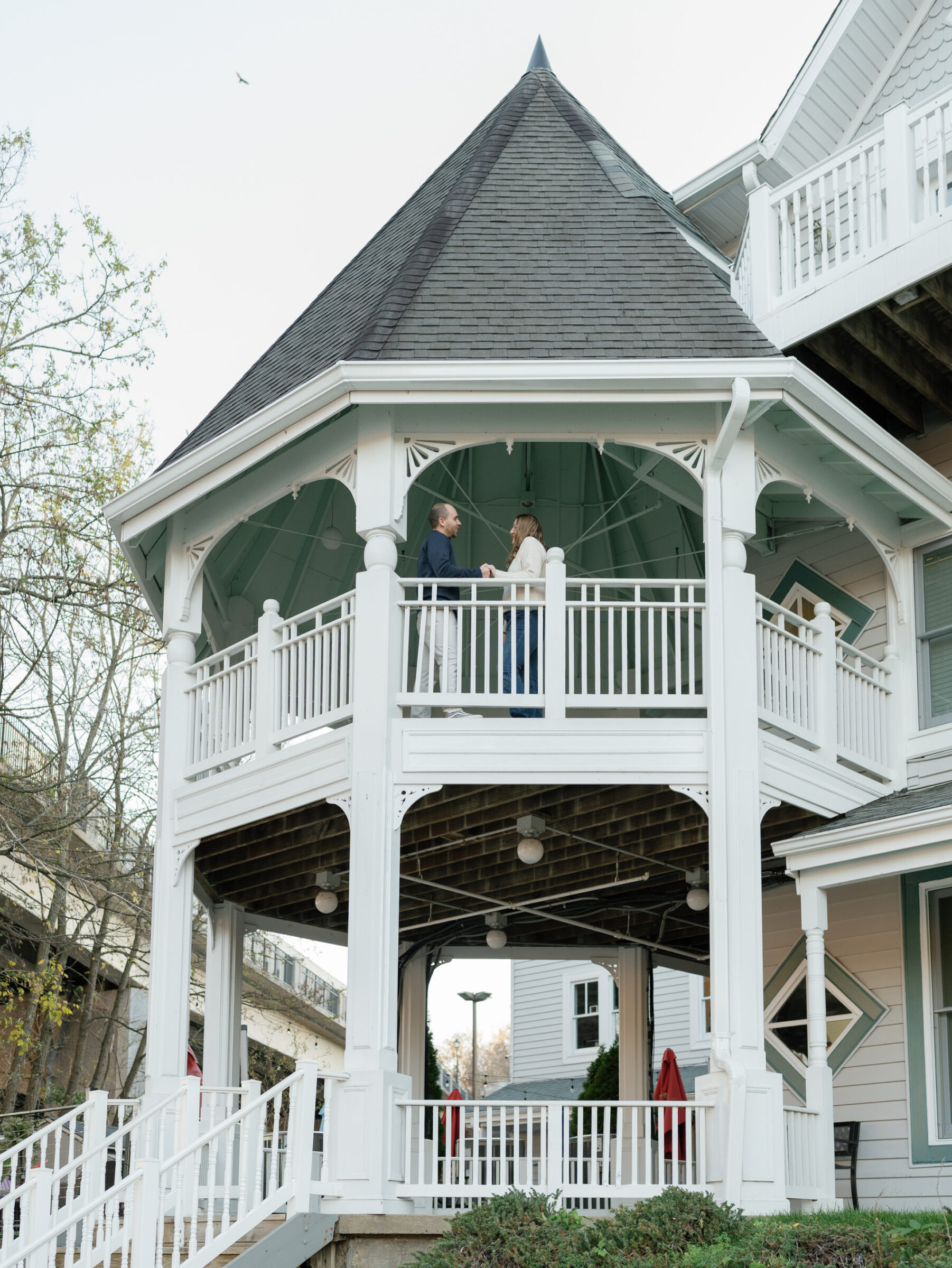 Couple standing together inside a large white gazebo overlooking the Occoquan River.