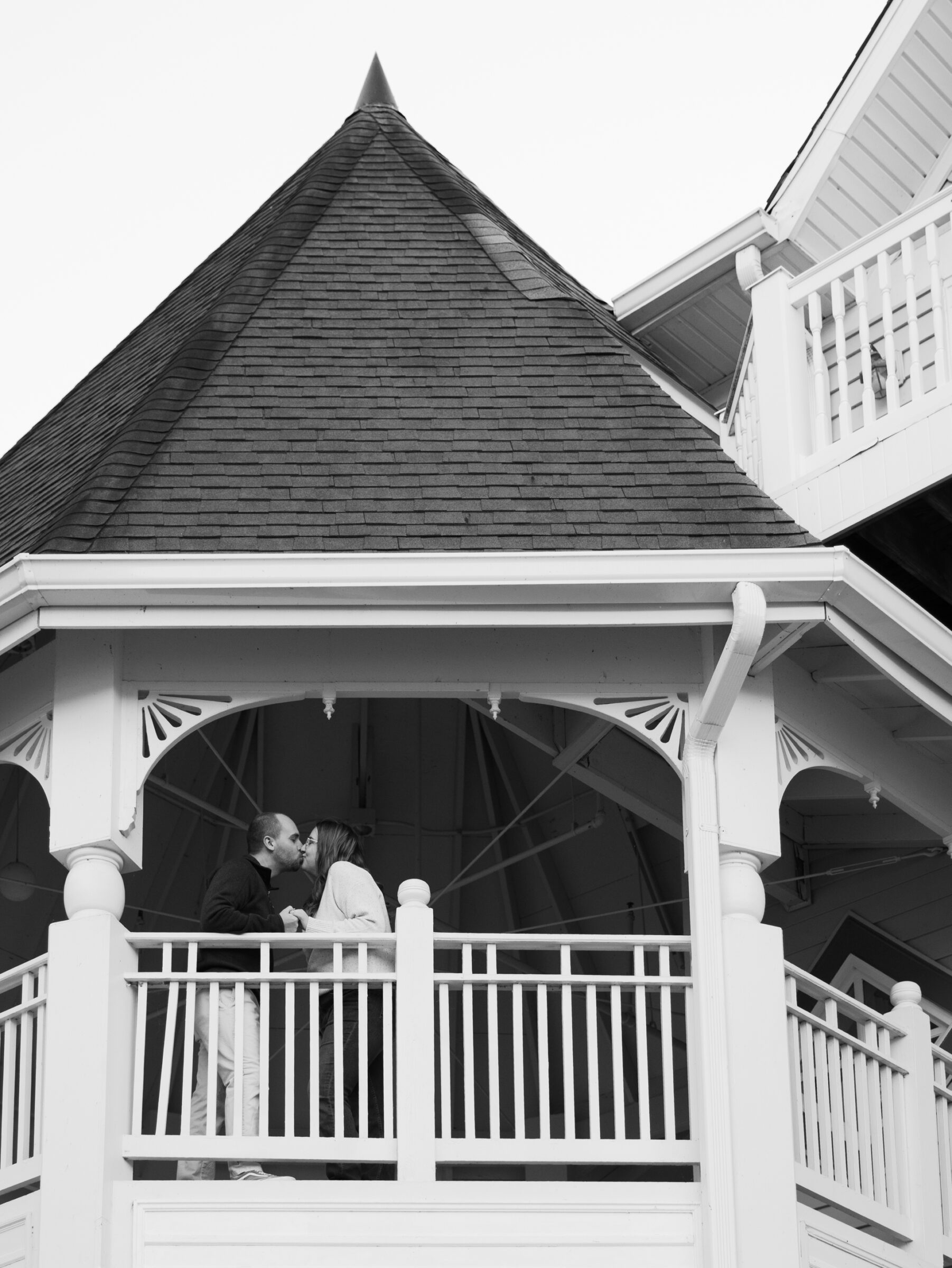 Couple sharing a kiss inside a white gazebo in Historic Occoquan during their engagement session.
