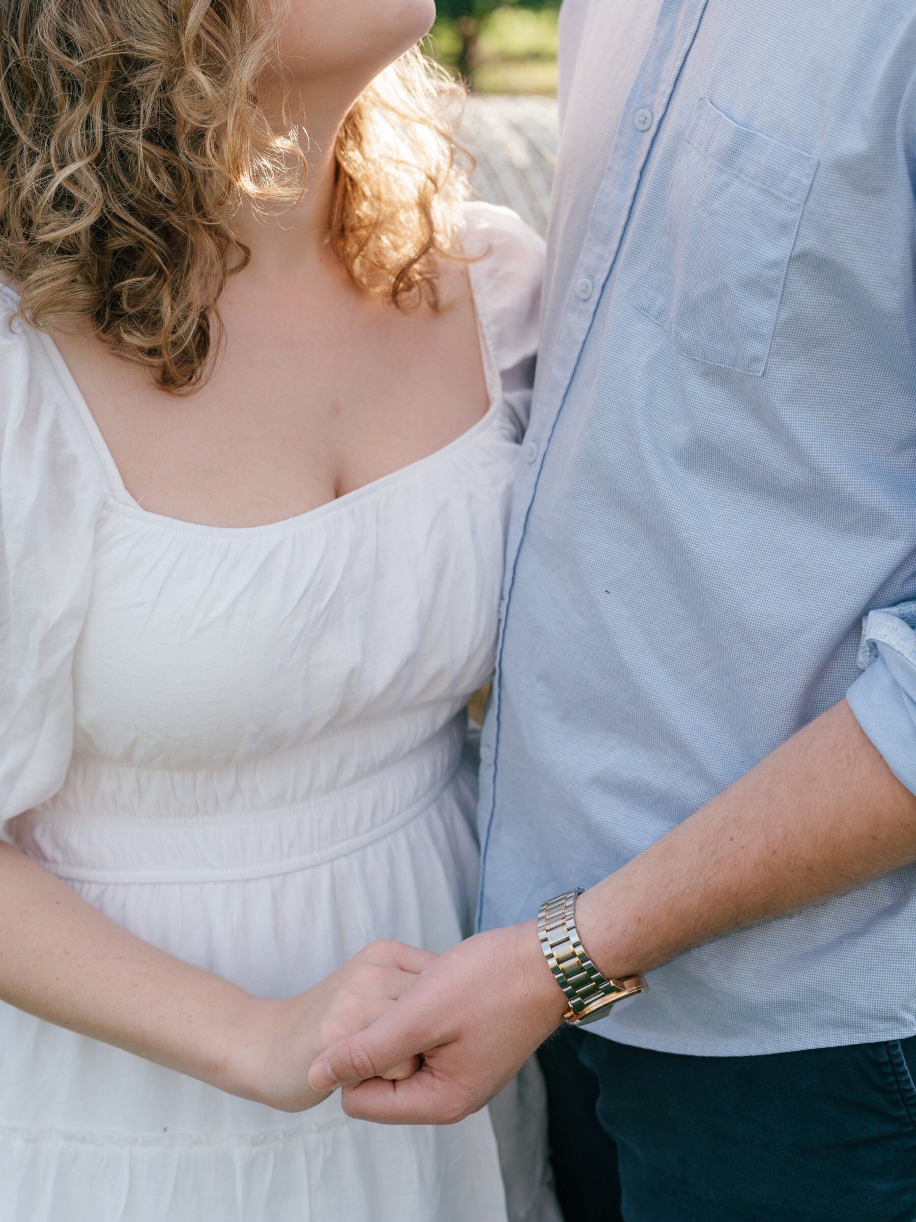 Intimate detail of an engaged couple holding hands during an at-home engagement session in Lovettsville, Virginia
