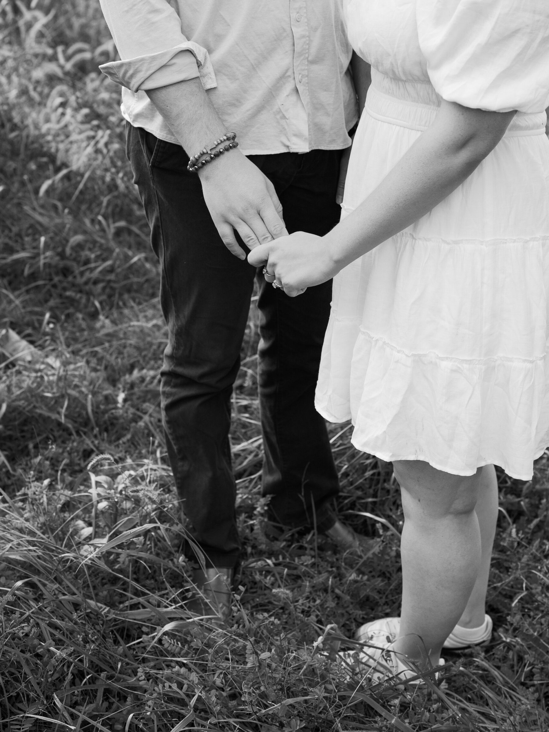 Black and white detail of an engaged couple holding hands during an intimate at-home engagement session in Lovettsville, Virginia