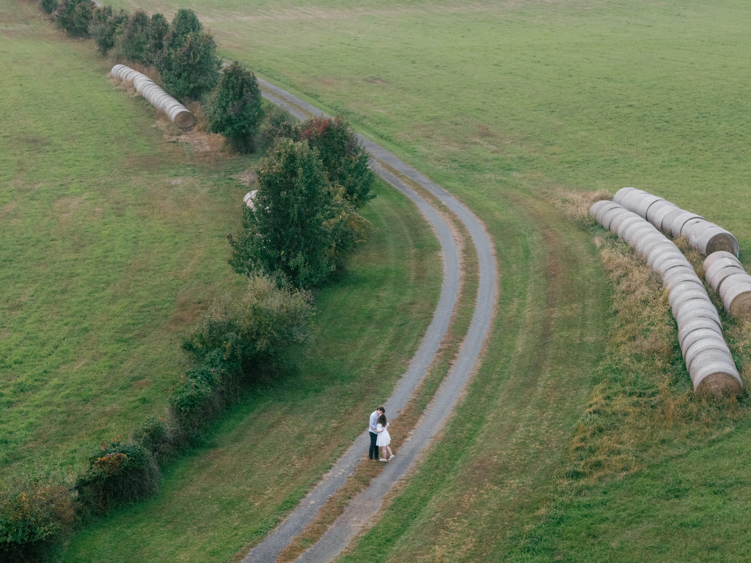 Lovettsville VA Wedding Photographer | Aerial view of an engaged couple standing together on a winding gravel drive during an at-home engagement session in Lovettsville, Virginia