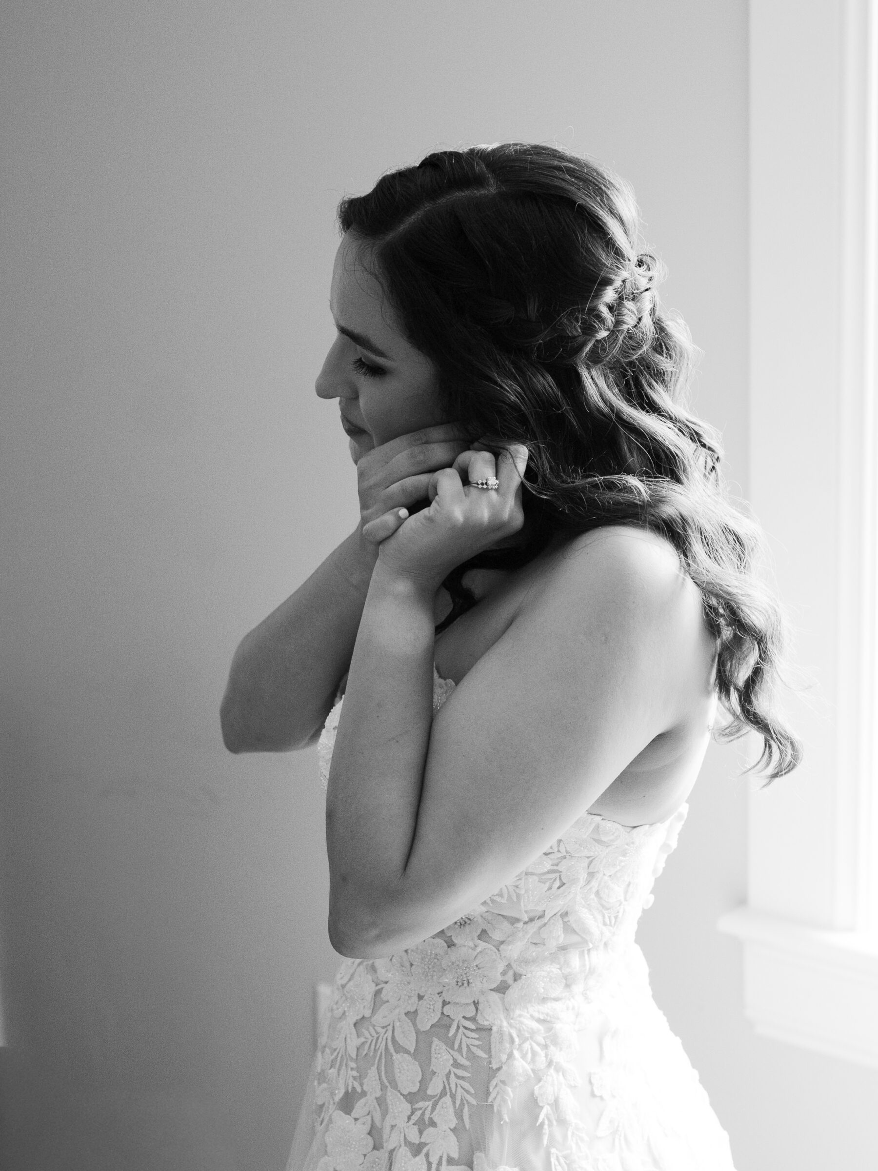 Bride adjusting her earrings during getting-ready moments at a scenic Bluemont VA wedding